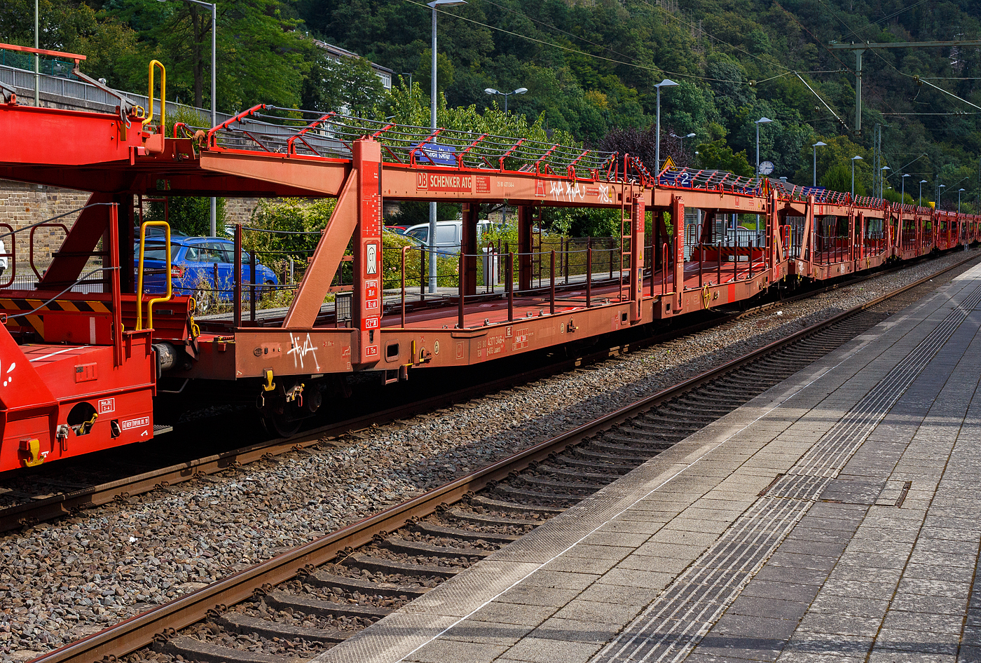 Leerer vierachsiger (2 x zweiachsiger) Doppelstock-Autotransportwagen 25 80 4371 346 D-ATG der Gattung Laaers 560.1 (BA 5.854) der DB Cargo Logistics GmbH (ex DB Schenker ATG) am 20 August 2024 im Zugverband bei der Durchfahrt in Kirchen (Sieg).

Der Wagen wurde 2011 von der damaligen DB Waggonbau Niesky GmbH gebaut.

Diese Waggons haben zwei Ladeebenen und sind für den europaweiten Transport geeignet. Sie werden für den internationalen Transport von PKWs, SUVs und Vans eingesetzt und bieten maximale Flexibilität durch eine stufenlos verstellbare obere Ladeebene. Aufgrund der hohen Lastgrenze (bis 34 t) ist der Transport von besonders schweren Fahrzeugen der genannten Typen möglich.

Damit sowohl ein typenreiner Transport als auch eine Mischverladung in den unterschiedlichen Lademaßen möglich ist, kann die obere Ladeebene hinsichtlich der Transportstellungen stufenlos eingestellt werden.

Durch die Entwicklung eines veränderten Ladungssicherungssystems wurde den Kundenanforderungen nach optimierten Transportmöglichkeiten für Fahrzeuge mit niedrigerer Bodenfreiheit Rechnung getragen.

TECHNISCHE DATEN:
Gattung: Laaers (Bauart 560.1)
Erstes Baujahr der Wagengattung: 2007
Spurweite: 1.435 mm
Anzahl der Achsen: 4 (2 x 2)
Länge über Puffer : 31.000 mm
Achsabstände: 10.000 mm / 5.160 mm / 10.000 mm
Laufraddurchmesser (neu): äußere 840 mm und mittlere 730 mm
Ladelänge : 30.070 mm (unten) / 30.550 mm (oben)
Ladelänge waagerechter Teil untere Ebene: 19.400 mm
Ladebreite : 2.950 (unten) / 2.750 mm (oben)
Höchstgeschwindigkeit: 100 km/h (120 km/h leer)
Eigengewicht: 31.000 kg
Max. Zuladung bei Lastgrenze S: 33,0 t (ab Streckenklasse B, bei A 29,0 t)
Max. Zuladung der Ladeebenen: unten und oben jeweils max. 18 t
Max. Gewicht je Pkw: 2.800 kg (Radlast max. 1 t)
Anzahl der Radvorleger: 64
Höhe Geländer oben: 600 mm
Kleinster befahrb. Gleisbogenhalbmesser: 75 m
Bremse: KE-GP-A (K)
Bremssohle: Jurid 816 M
Handbremse: Ja
Intern. Verwendungsfähigkeit: TEN-GE

Der große Unterschied zwischen den Laaers-Wagen der Bauart 560.1  (wie hier) und der Bauart 560.2 sind das Lastgrenzenraster (Max. Zuladung), die Bauart 560.1 ist meist 500 kg schwerer als die Bauart 560.2.

