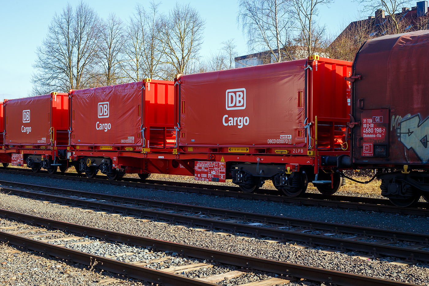 NEUHEIT - Die neusten Güterwagen DB Cargo AG
Neuer vierachsiger Drehgestell-Güterwagen (Tragwagen) 31 80 9300 179-6 D-DB der Gattung Uas 224.2 der DB Cargo AG am 17 Februar 2025 abgestellt, im Zugverband eines Übergabegüterzuges, in Herdorf auf dem KSW Rbf Herdorf (Betriebsstätte Freien Grunder Eisenbahn - NE 447). Der Wagen (m² Wagen 45ft) ist hier beladen mit zwei Coil-Behältern (20-Fuß-Container), welche bis zu 3 Blech-Coils mit einem Gesamtgewicht bis zu 30 t aufnehmen kann.

TECHNISCHE DATEN Wagen (laut Anschriften):
Gattung: Uas 224.2
Spurweite: 1.435 mm (Normalspur)
Länge über Puffer: 15.220 mm
Drehzapfenabstand: 9.680 mm
Radsatzstand in den Drehgestellen: 1.800 mm
Eigengewicht: 18.200 kg
Max. Zuladung: 71,8 t (ab Streckenklasse D)
Max. Geschwindigkeit: 100 km/h (beladen) / 120 km/h (leer)
Kleinster Gleisbogenhalbmesser: 75 m
Bauart der Bremse: KE-GP-A (K)
Bremssohle: Cosit 810
Handbremse: Ja (an einem Drehgestell)
Intern. Verwendungsfähigkeit: TEN-GE

Der multifunktionale und modulare Güterwagen m² ist eine neue und innovative Technologie für den Güterwagen der Zukunft. Das Konzept wurde in Zusammenarbeit von DB Cargo und VTG entwickelt.

Die heutigen Güterwagenflotten sind geprägt durch eine große Diversifizierung des Wagenparks, mit vielen unterschiedlichen Bauarten und mangelnder Flexibilität hinsichtlich des Einsatzes und der Verwendung. So werden Wagen für den Transport bestimmter Güter für einen Zeitraum von mehreren Jahrzehnten beschafft und es besteht im Lebenszyklus keine Möglichkeit, den Einsatzzweck zu verändern. Die ausgeprägte Spezialisierung der heutigen Güterwagenbeschaffung führt zu einem erhöhten Risiko von Fehlinvestitionen über den langen Lebenszyklus der Fahrzeuge.

Der m²-Güterwagen basiert auf einem Untergestell als variable Plattform mit veränderbarer Länge. Darauf können die verschiedensten Behälter zum Transport unterschiedlicher Güter montiert werden. Dieses innovative Konzept eines multifunktionalen und modularen Güterwagens ermöglicht eine flexible Nutzung durch Kombination aus wirtschaftlichem Baukastenprinzip (modular) und einer vielseitig einsetzbaren Verwendung (multifunktional).

Die Zulassung eines Güterwagens als komplettes und flexibles System ist ein echter Meilenstein. 

Merkmale:
▪ modularer Tragwagen zum Transport von kundenindividuellen Behältern
▪ Zulassung als Güterwagensystem seit 31.05.2021 vorliegend
▪ Anpassung wesentlicher Wageneigenschaften im Lebenszyklus ohne erneute Zulassung möglich
▪ Wagen ist an sich ändernde Marktanforderungen durch Modularität flexibel anpassbar
▪ Längen des Tragwagens im Lebenszyklus veränderbar
▪ Behälter sowie Aufbauten tauschbar und Kopplungsmöglichkeiten mit Wagen gegeben
▪ Uneingeschränkte EV-Fähigkeit des Tragwagens

Persönliche Anmerkung: Eine solcher mit 2 Coilbehälter ist um ca. 3 m länger als z.B. ein Coilwagen der Gattung Shimmns, aber dafür haben die Behälter, mit den Gabelstaplertaschen und den Containereckbeschlägen, vielfältige Umschlags- und Lagermöglichkeiten.

Die Coil-Behälter:
Hersteller: Wecon GmbH
Hersteller der Plane: Schleswiger Tauwerkfabrik Oellerking GmbH & Co. KG

Ausstattungsmerkmale sind:
− Leichtgängige Plane mit Antikondensatiosvlies
− Schnee- und Nässeschutz durch Gummilippe, Bürste und Regenrinne
− Ladungssicherung über Klaviatursicherung
− Planenfesttellbremse und Gitterroste zur Maximierung der Arbeitssicherheit
− Gabelstaplertaschen und Containereckbeschläge für vielfältige Umschlagsmöglichkeite

Dimensionen der Mulden:
Mulde 1 für Ø 780 bis 1.650 mm, mit max. 17 t
Mulde 2 für Ø 780 bis 2.100 mm, mit max. 30 t
Mulde 3 für Ø 780 bis 1.650 mm, mit max. 17 t
Die max. Ladebreite beträgt jeweils 2.240 mm, die max. Zuladung eines Containers beträgt mit 30 t. 

Containermaße (außen): 
Länge: 6.058 mm (20 ft.)
Breite: 2.438 mm
Höhe: 2.591 mm
Leergewicht: 4,5 t
Zuladung: 30 t
