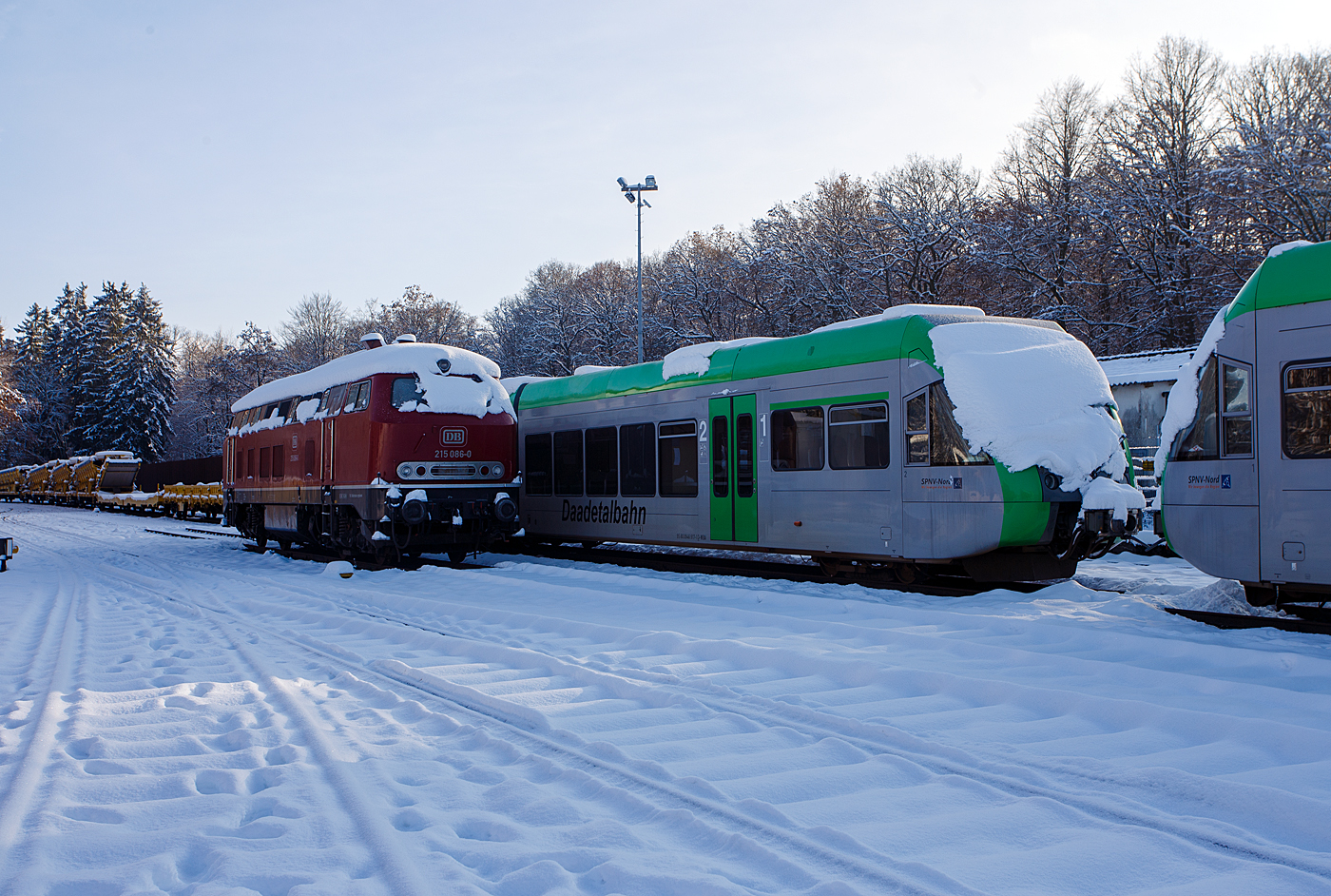 Nicht nur im Süden der Republik hat es etwas geschneit, wie hier auf dem Westerwald auf der Bindweide, aber nicht so mächtig. Die für Steilstrecken zugelassenen 215 086-0 (eigentlich 225 086-8 / 92 80 1225 086-8 D-EVG) der RE - Rheinische Eisenbahn ist am ersten Advent dem 3 Dezember 2023 auf dem Betriebshof der Westerwaldbahn (WEBA) auf der Bindweide bei Steinebach/Sieg abgestellt. Rechts stehen noch die beiden Daadetalbahn STADLER GTW 2/6 VT 117 und VT 118 (646 417-5 und 646 418-3) der Westerwaldbahn (WEBA), ex VT 117 und ex VT 118 HellertalBahn, die beiden gingen nach Auflösung der HellertalBahn an die WEBA, der 3. der VT 116 ging an die HLB. 