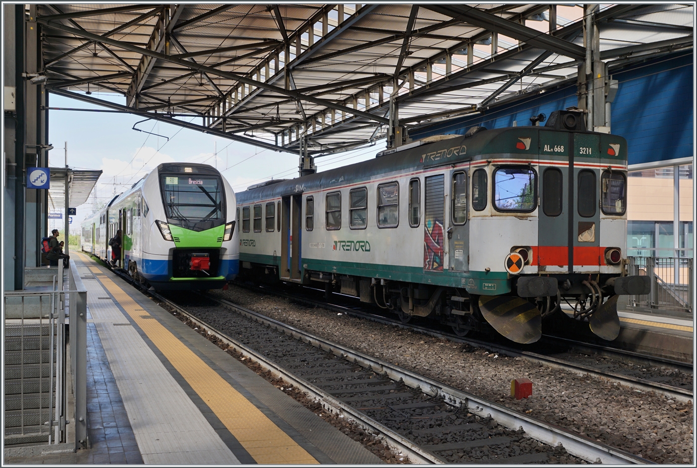 Noch fahren auf der von Trenord betriebenen Strecke Parma - Brescia (R8) die Aln 668, wie der rechts im Bild zu sehende Aln 668 3211 zeigt; doch die Ablösung steht schon bereit: 
Links im Bild wartet ein ATR 803 als Trenord R8 Regional 10826 auf die Abfahrt nach Brescia.

16. April 2023