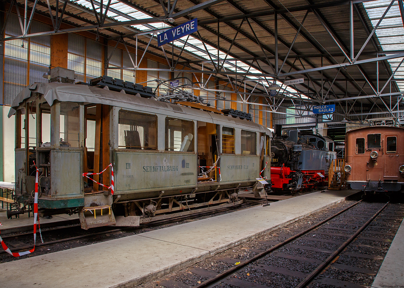 Noch in der Restaurierung (Aufarbeitungsfase) der 2./3. Klasse elektrische Personentriebwagen mit Gepäckabteil der ehemalige Sernftalbahn SeTB  BCFe 2/2 4 der Museumsbahn Blonay–Chamby, am 27.05.2023 in der Halle der (BC) in Chaulin.

Der Personen- und Gepäcktriebwagen wurde 1928 von der SIG (Schweizerische Industrie-Gesellschaft) in Neuhausen am Rheinfall und der elektrische Teil ist von der MFO (Maschinenfabrik Oerlikon gebaut, und an die SeTB geliefert. Die Sernftalbahn (SeTB) war eine elektrische Meterspurbahn (1.000 mm) im Schweizer Kanton Glarus, sie bestand von 1905 bis 1968) und führte, meist auf der Talstraße, von Schwanden aus durch das Sernftal 13,8 Kilometer entlang des namensgebenden Flusses aufwärts bis nach Elm. Die Triebwagen wurden mit Gleichstrom (750  V, später 800 V) aus einem eigenen Wasserkraftwerk und einer Dieselmotor-Generatoren-Gruppe angetrieben. Die Betriebsleitung befand sich in Engi in der Mitte der Strecke. Nach der Einstellung der Bahn wurde der Triebwagen, wie auch der Personenwagen BC 13 und der Güterwagen K 31, 1969 an die Museumsbahn Blonay–Chamby (BC) abgegeben.

TECHNISCHE DATEN:
Spurweite: 1.000 mm
Achsfolge: A’A’
Länge über Puffer : 10.420 mm
Achsstand: 4.700 mm
Triebraddurchmesser: 860 mm (neu)
Eigengewicht: 15,2 t 
Leistung: 2 × 64 kW = 128 kW (2 x 87 PS = 174 PS)
Getriebeübersetzungen: 1:5,92
Zul. Höchstgeschwindigkeit: 30 km/h 
Stromsystem: ursprünglich 850 V DC (Gleichstrom) / bei der BC 1.000 V
Stromabnehmer: 1 Scheren-Stromabnehmer, Betätigung über Schnur
Max. Neigung : 68 ‰  (SeTB)
Sitzplätze: 6 (2. Klasse), 12 (3. Klasse) 
Gepäckabteilgröße: 4 m²
Max. Gepäck Zuladungsgewicht: 3,0  t

Quellen: BC,
