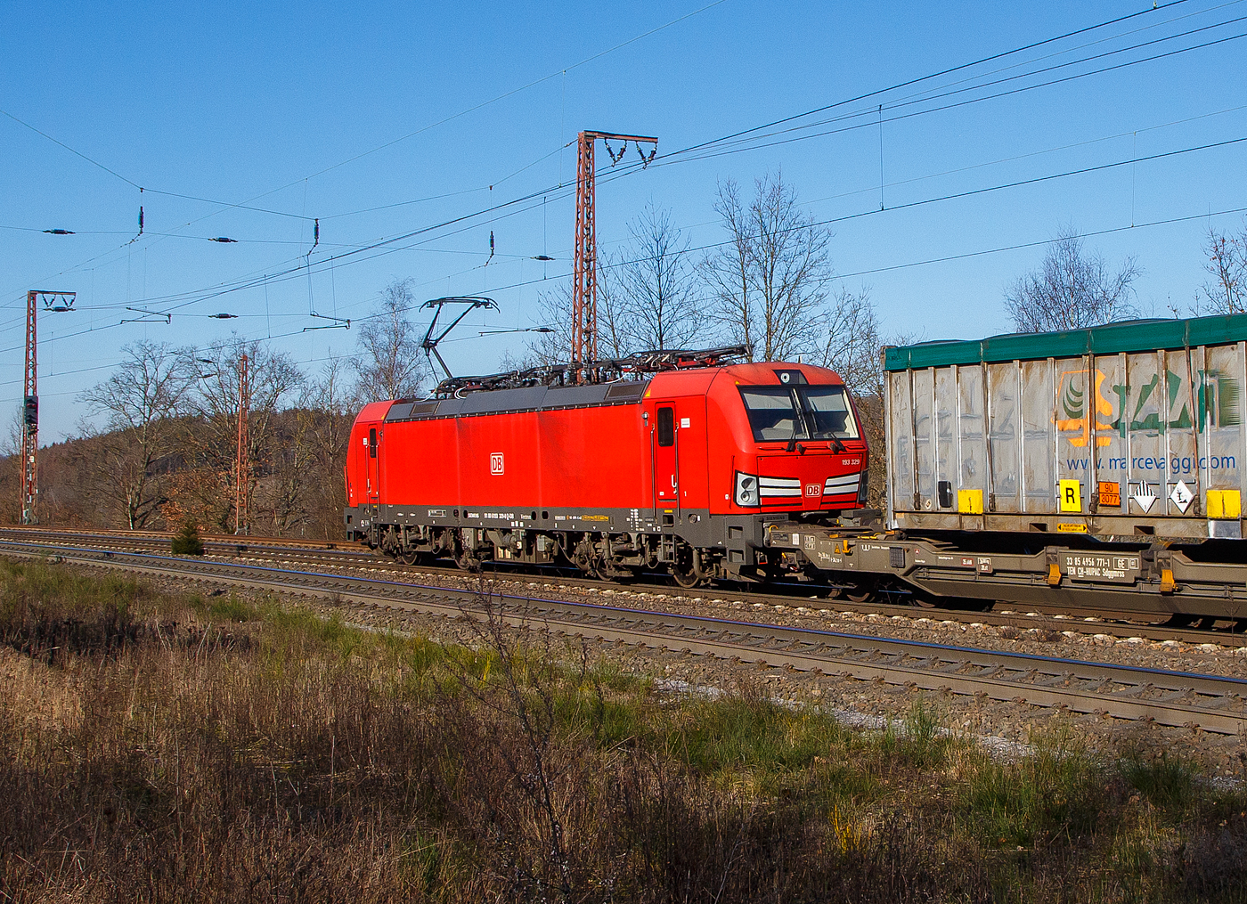 Nochmal als Nachschuss...
Die 193 329-0 (91 80 6193 329-0 D-DB) der DB Cargo AG fährt am 07.2.2023 mit einem „HUPAC“ KLV-Zug durch Rudersdorf (Kr. Siegen) in Richtung Siegen. Hier befährt der Zug die Dillstrecke (KBS 445) von dieser geht es bei Siegen-Ost auf die Siegstrecke (KBS 460) in Richtung Köln. Weil die Ruhr-Sieg-Strecke (KBS 440) nicht das KV-Profil P/C 400 aufweist, sind solche Züge dort nur bis Kreuztal zum Südwestfalen Container-Terminal möglich.

Die Siemens Vectron MS (200 km/h - 6.4 MW) wurden 2018 von Siemens unter der Fabriknummer 22404 und gebaut, sie hat die Zulassungen für Deutschland, Österreich, Schweiz, Italien und die Niederlande (D/A/CH/I/NL).