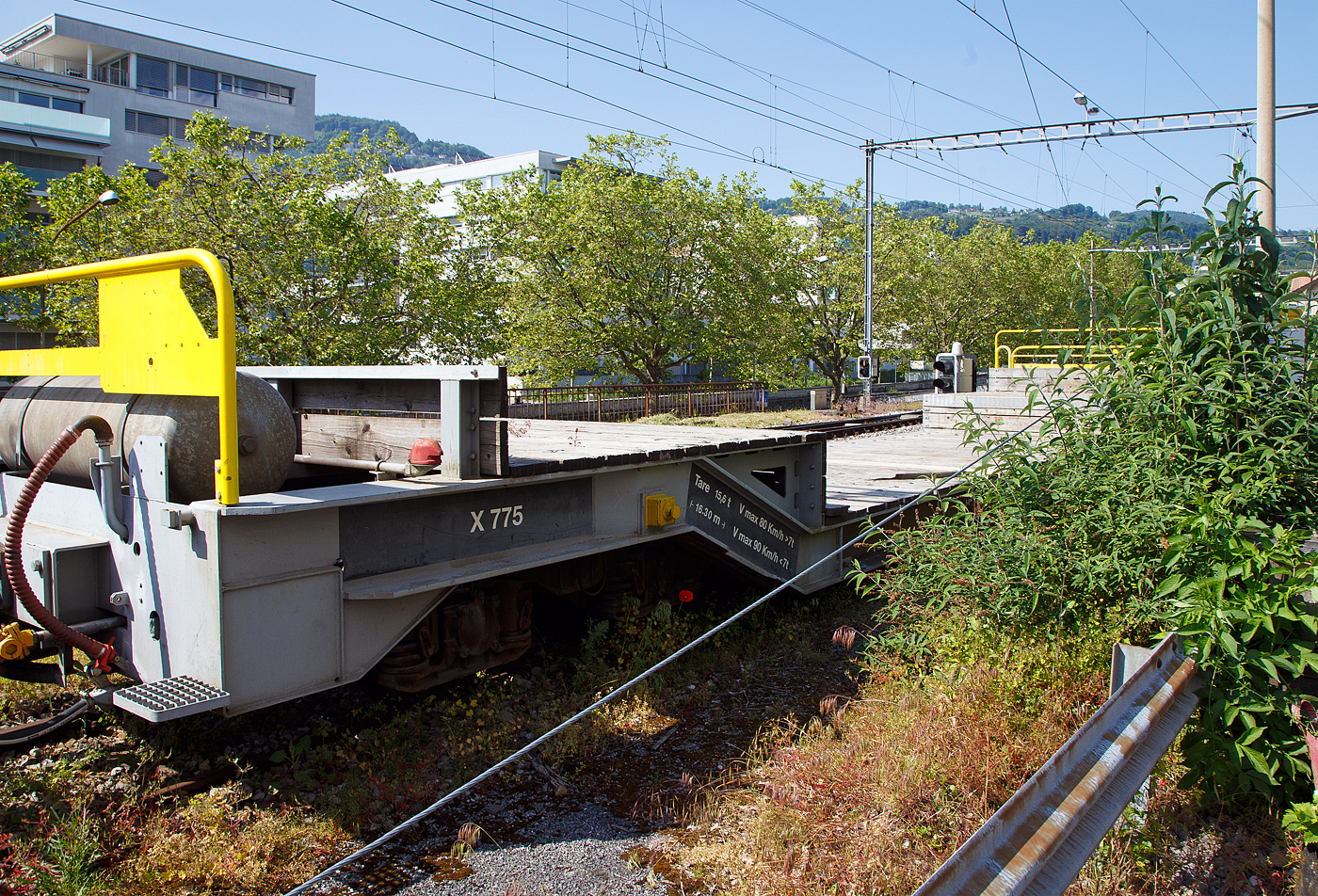 Nochmal im Detail der vierachsige Drehgestell-Tiefbett-Flachwagen als Dienstgüterwagen MOB X 775 der Montreux-Berner Oberland-Bahn, ex RhB Sbk-v 7705, abgestellt am 26.05.2023 in Vevey.

Der Wagen wurde 1999 von der Josef Meyer Waggon AG in Rheinfelden (CH) unter der Fabriknummer 2314 gebaut und an die RhB (Rhätische Bahn AG - Bündner Güterbahn) als Niederflur-Containerwagen Sbk-v 7705 (RhB Serie Sbk-v 7701-7715) geliefert. Im Februar 2013 wurde der Wagen bei der RhB ausrangiert und an die MOB verkauft. Bei der MOB wurde der Wagen umgebaut und an die MOB Normalien angepasst. Zum Umbau gehörte die komplette Belegung des Stahlrahmens mit Holzbohlen, so wurde aus dem Containerwagen ein Tiefbettflachwagen, das Eigengewicht stieg von 14,2 t auf nun 15,6 t. Im Juni 2013 erfolgte die Inbetriebnahme als X 775 bei der MOB.
