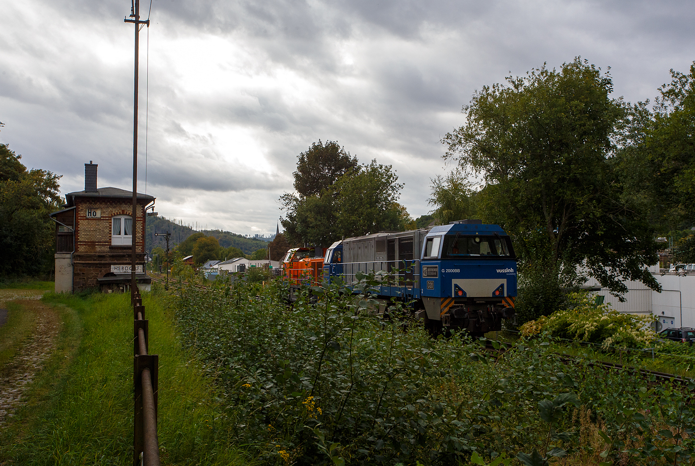 Nun am 18 September 2025 verlassen die KSW 44 (92 80 1271 004-4 D-KSW) eine MaK G 1000 BB und die an die KSW vermietete 272 408-6 / D20 der Bentheimer Eisenbahn AG (92 80 1272 408-6 D-BE), ex Rurtalbahn V 203 (92 80 1272 408-6 D-RTBC), eine Vossloh G 2000BB (mit symmetrischem Führerhaus), beide gemeinsam wieder den KSW-Rangierbahnhof (Betriebsstätte FGE - Freien Grunder Eisenbahn) in Herdorf und fahren über die Hellertalbahn in Richtung Betzdorf/Sieg zurück um neue Aufgaben zu erfüllen. Zuvor hatten sie im Sandwich einen sehr langen und schweren Coilzug nach Herdorf gebracht. Für die weitere Fahrt war dann die KSW 47 zuständig, die den Zug in 2 bis 3 Partien von Herdorf nach Neunkirchen-Salchendorf abfuhr. 