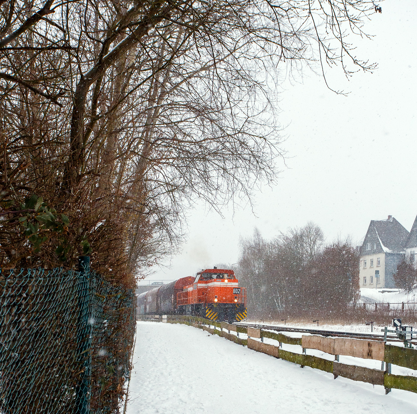 Nun hat es angefangen kräftig zu schneien, die HLB RB 96 „Hellertalbahn“ ist durch und die zurzeit an die KSW (Kreisbahn Siegen-Wittgenstein) vermietete RBH 802 „Ruhrpott Sprinter“ / 275 802-3 (98 80 0275 802-3 D-RBH), eine MaK G 1206 der RBH - RAG Bahn und Hafen GmbH (Gladbeck), kann die Fahrt mit einem Übergabegüterzug beginnen. Der Zug geht via Betzdorf/Sieg und Siegen zum Gbf der DB Cargo in Kreuztal.

Die MaK G 1206 wurde 1997 von der Siemens Schienenfahrzeugtechnik (SFT) in Kiel-Friedrichsort unter der Fabriknummer 1000901 gebaut und an die damalige RAG - Ruhrkohle AG, RAG Bahn- und Hafenbetriebe in Gladbeck als RAG 802 ausgeliefert. Sie war erst die zweite gebaute Lok der erfolgreichen Typs G 1206 aus dem 3. Typenprogramm. Im Jahr 2004 erfolgte die Umfirmierung der RAG in RAG Bahn und Hafen GmbH (RBH) und nach der Übernahme durch die DB Schenker Rail Deutschland AG (heute DB Cargo) erfolgte 2006 die Umfirmierung in RBH Logistics GmbH.