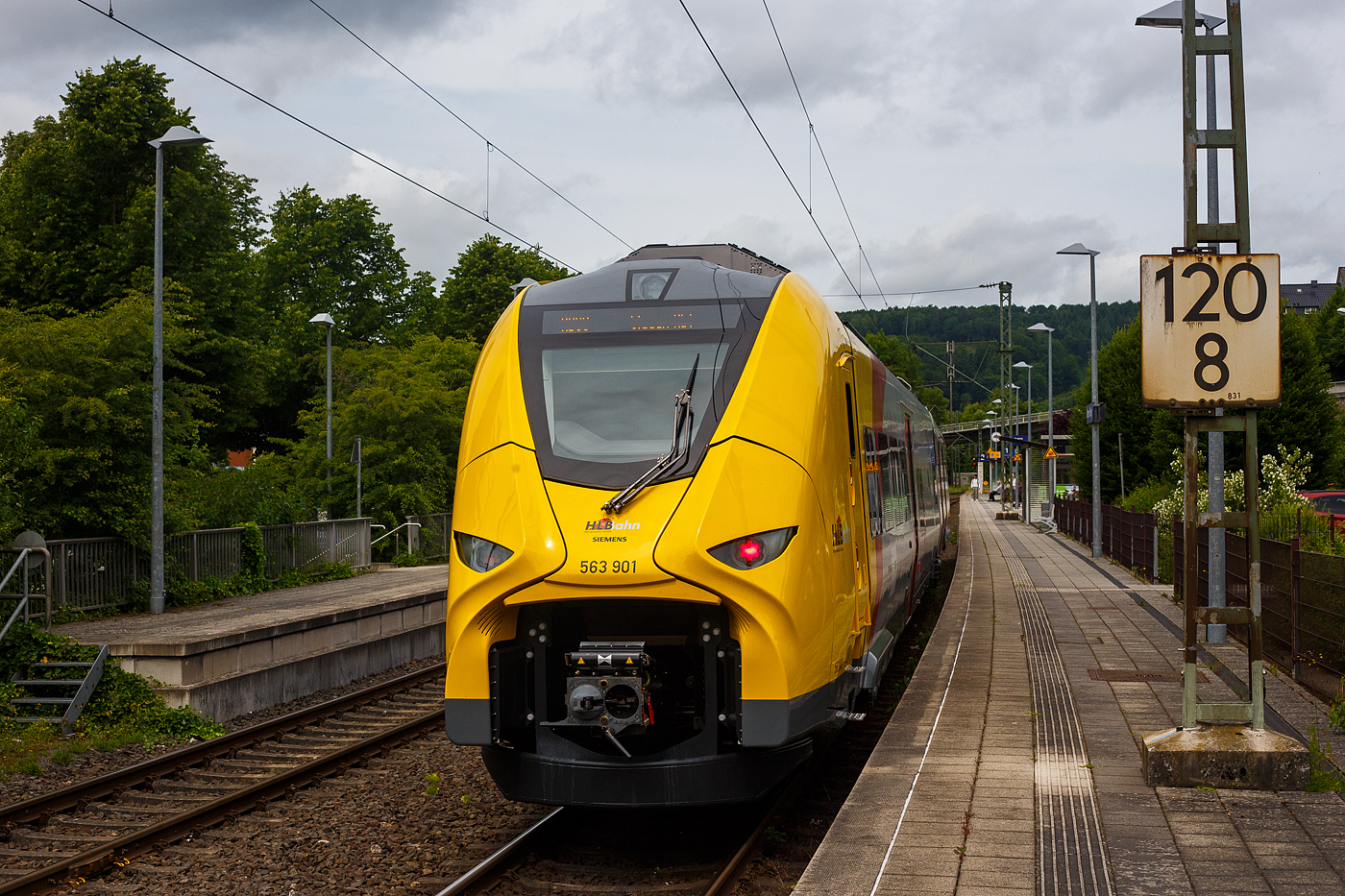 Nun sind die HLB SIEMENS Mireo Plus B wohl schon im Planbetrieb: Der HLB 563 801 / 563 901 (94 80 0563 801-0 D-HEB / 94 80 0563 901-8 D-HEB), ein zweiteiliger Hybridtriebzug (E/Akku) der BR 563 vom Typ SIEMENS Mireo Plus B der HLB (Hessische Landesbahn GmbH), erreicht am 04 Juni 2025, als RB 90  Westerwald-Sieg-Bahn  (Limburg/Lahn - Westerburg - Altenkirchen/Westerwald - Au/Sieg - Betzdorf/Sieg – Siegen), im Batteriemodus (Stromabnehmer sind unten) den Bahnhof Kirchen/Sieg. 

Nochmals einen lieben Gruß an den netten Triebfahrzeugführer zurück. 

Der zweiteilige SIEMENS Mireo Plus B wurden 2024/25 von SIEMENS in Krefeld gebaut und im April 2025 an die HBL ausgeliefert.

Warum im Batteriemodus gefahren wird, kann ich nur vermuten das man die Reichweite mit einer Akkuladung testen will. Dann aber schonmal Hut ab / Chapeau (alle Achtung und allen Respekt!), denn von Limburg bis Kirchen hat er dann ca. 100 km zurückgelegt. 