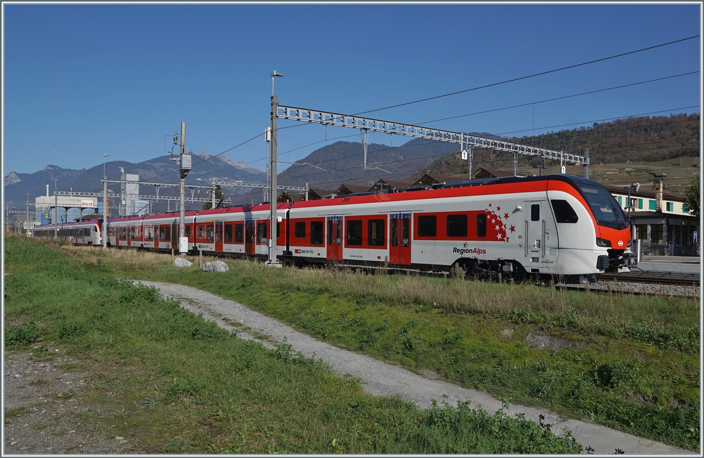 Nun werden sie wohl bald im Planbetrieb zu sehen sein die ersten neuen EVO RA Triebzüge, hier noch bei einer Testfahrt in Bex zu sehen: der neue RegionAlps RABe 533 703. Dahinter der SBB RABe 531 002. Interessanterweise ist der  RegionAlpes Triebzug trotz unterschiedlicher Farbgebung, einer anderen Einteilung der 1. Klasse und einer anderen Baureihen Bezeichnung ein SBB Triebzug, wie jedenfalls die UIC Nummer verkündet: RABe 94 85 0 533 703-0 CH-SBB.

30. Oktober 2024