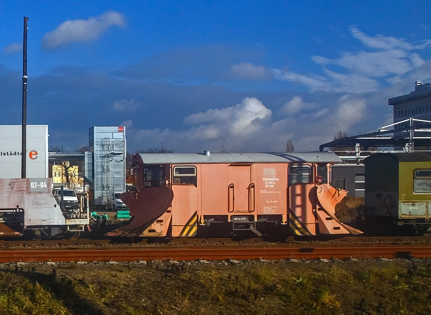 Obwohl die Zugehörigkeit zur DB sehr kurz war, ist dieser Schmalspur-Schneepflug 97-09-42  SPS 038 noch im DB Design.....
Der zweiachsige Schmalspur (750mm) Schneepflug 97-09-40  SPS 036 der Lößnitzgrundbahn (zur SDG - Sächsische Dampfeisenbahngesellschaft mbH), am 08.12.2022 in Radebeul Ost, aufgenommen aus einem IC).

Diese Serie von zweiachsigen nicht selbstfahrenden Schneepflügen (Neubauschneepflug) der Bauart 805 endstanden 1988 bis 1990 im Raw Meiningen eine welche für alle Schmalspurbahnen geeignet waren und nur die Spurweite verändert werden musste. Die Hauptpflugschare können zwischen 40 mm und 130 mm über Schienenoberkante angehoben werden. Außerdem sind zwei kleinere Pflugschare unter dem Wagenboden vorhanden, welche auch zwischen den Schienen räumen können.

TECHNISCHE DATEN:
Bauart: 805
Hersteller: RAW Meiningen
Baujahr: 1989
Spurweite: 750 mm
Achsanzahl: 2
Achsabstand: 4.000 mm
Länge über Kupplung: 9.350 mm
Eigengewicht: 16.800 kg
Höchstgeschwindigkeit.: 30 km/h
Zulässige Personenzahl zur Mitfahrt: 6
Kupplungstyp: Scharfenbergkupplung
