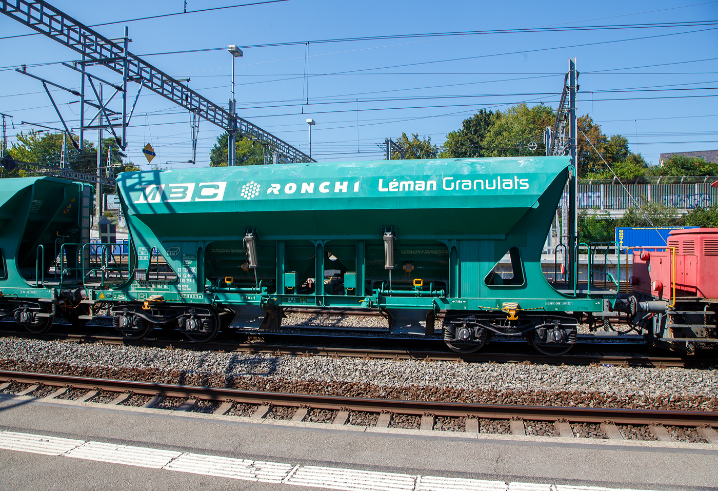 Offener 4-achsiger Drehgestell-Schüttgutwagen mit dosierbarer Schwerkraftentladung 33 54 6985 257-8 CZ-MBC der Gattung Faccns der MBC (Transports de la région Morges–Bière–Cossonay, ex BAM - Compagnie du Chemin de fer Bière–Apples–Morges am 07.09.2023 im Bahnhof Morges. Interessant ist die Tatsache dass der Heimatbahnhof der Wagen Morges (CH) ist, aber die Wagen in Tschechien eingestellt sind.

Die Wagen wurden vom tschechischen Waggonbauer LEGIOS a.s. in Louny (ex ŽOS Louny – Železniční opravny a strojírny Louny) gebaut, seit 2021 heißt das Unternehmen wieder LOSTR und gehört offensichtlich zur Wascosa AG (Schweiz).

Im Herbst 2013 nahm die MBC/BAM den Transport, für die RONCHI Léman Granulats, von etwa 170 000 Tonnen Kies pro Jahr aus Apples nach Morges und weiter auf der SBB-Strecke nach Gland auf. Um die Kiesgrube auszufüllen, befördert die MBC in der Gegenrichtung 100 000 Tonnen Aushubmaterial. Dafür wurden 20 geeignete normalspuriger Güterwagen gekauft.

Der Drehgestell-Schüttgutwagen Faccns ist für den Transport von nässeunempfindlichem Material geeignet. Die Entladung kann über Band- und Tiefbunkeranlagen erfolgen, ist dosierbar, tiefliegend, wahlweise zweiseitig und erfolgt per Schwerkraft. Die Neigung der Trichterwände beträgt 50°. Das Ladevolumen beträgt 48 m³. 

TECHNISCHE DATEN:
Spurweite: 1.435 mm (Normalspur)
Achsanzahl: 4
Länge über Puffer: 12.680 mm
Drehzapfenabstand: 7.880 mm
Achsabstand im Drehgestell: 1.800 mm
Laufraddurchmesser: 920 mm (neu)
Laderaum: 48 m³
Höchstgeschwindigkeit: 100 km/h (beladen) / 120 km/h (leer)
Maximales Ladegewicht: 68,75 t (ab Streckenklasse D3)
Eigengewicht: 21.250 kg
Kleinster bef. Gleisbogenradius: 75 m
Bremse: KE-GP-A (K)
Bremssohle: Cosid 810
Intern. Verwendungsfähigkeit: TEN-GE

Wobei die Ladegewichte und die Höchstgeschwindigkeit sich auf die Normalspur beziehen, bei der MBC werden die Wagen aber für die Strecke Morges – Apples auf Schmalspur (Meterspur) Rollböcke verladen. 
