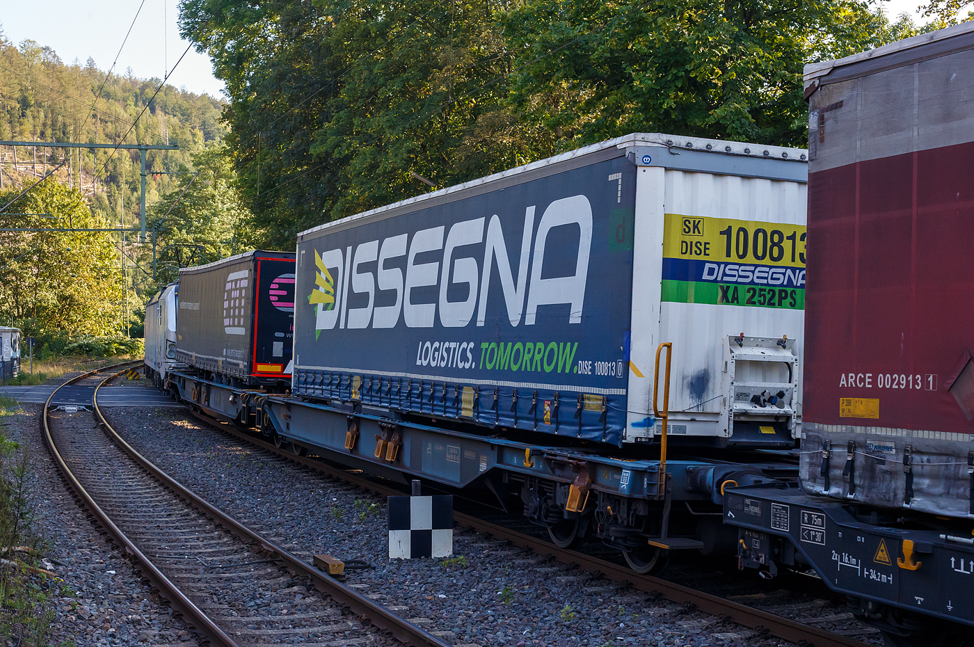 Sechsachsiger Gelenk-Taschenwagen (Doppeltaschenwagen T2000), 37 80 4993 597-6 D-WASCO, der Gattung Sdggmrs T2000, der der WASCOSA AG, am 17 September 2024 im Zugverband bei der Durchfahrt im Bahnhof Kirchen (Sieg), hier beladen mit zwei Sattelanhängern (Trailer).

Diese Wagen vom Typ T2000 wurde von Tatravagónka a.s. in Poprad (Slowakei) gebaut, die Entwicklung und Konstruktion ist von der Ferriere Cattaneo SA in Giubiasco (Schweiz). Baugleiche Wagen sind u.a. auch für die DB Cargo AG, bezeichnet als Sdggmrs 736, unterwegs. Sie sind aber auch bei anderen Halteren im Einsatz, wie z.B. bei der AAE heute VTG als Sdggmrs(s) Megapack (T2000), VTG-Typ T72.104D bezeichnet.

Die Wagen dienen dem Transport von jeweils zwei Sattelaufliegern von maximal 13.600 mm Länge. Jede Wagenhälfte verfügt über einen in Längsrichtung verschiebbaren Stützbock zur Aufnahme von Sattelanhänger mit einem Gesamtgewicht von bis zu 40t. Die Sattelanhänger werden mit Hilfe von Radvorlegern (4 je Wagenhälfte) festgelegt. Für die Beförderung von Containern oder Wechselbehältern bis zu 2 × 45 Fuß, verfügen die Wagen über 20 klappbare, und zum Teil auch verschiebbare Containerzapfen. Für lange Wechselbehälter gibt es eine Mittenunterstützung.

TECHNISCHE DATEN:
Spurweite: 1.435 mm (Normalspur)
Länge über Puffer: 34.200 mm
Drehzapfenabstand: 2 x 14.200 mm
Achsabstand in den Drehgestellen: 1.800 mm
Laufraddurchmesser: 920 mm (neu) / 860 mm (abgenutzt)
Drehgestelle:  1 x Y25 Ls(s)i – k / 2 x Y25 Ls(s)if-k
Radsätze: BA 318
Eigengewicht: 34.600kg
Max. Zuladung bei Lastgrenze S: 100,4 t (ab Streckenklasse D)
Max. Geschwindigkeit: 100 km/h (bei Lastgrenze S) / 120 km/h (leer)
Kleinster befahrbarer Kurvenradius: R 75 m (R 150 m im Zugverband)
Bremse: 2 x KE-GP-A (K)
Bremssohle: Jurid 816M (K-Sohle)
Handbremse: am mittleren Drehgestell
Intern. Verwendungsfähigkeit: TEN-GE / G1