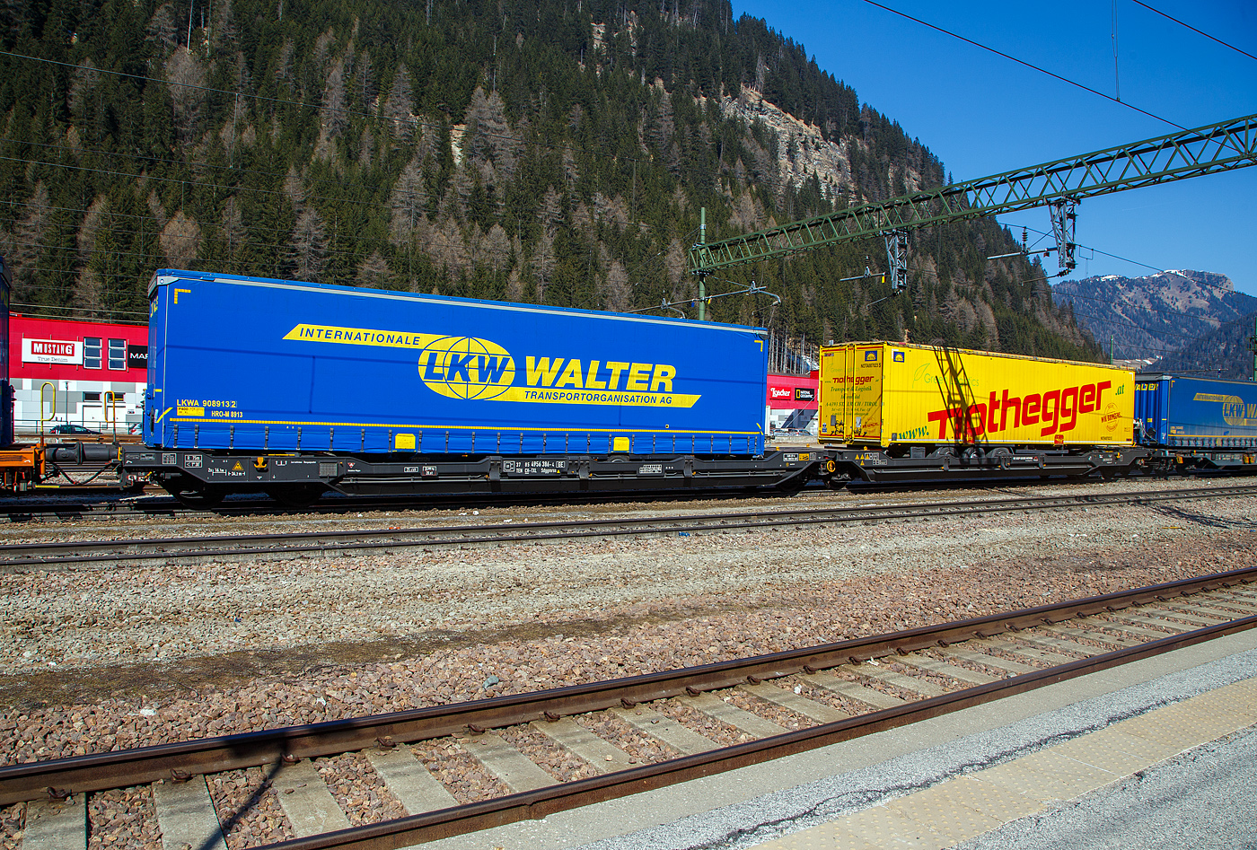 Sechsachsiger Gelenk-Taschenwagen (Doppeltaschenwagen T3000e), 37 85 4956 386-4 CH-TXL, der Gattung Sdggmrss, der TX Logistik AG (Troisdorf), am 28 März 2022 im Zugverband im Bahnhof Brenner /Brennero, hier beladen mit zwei Sattelanhängern. Die TXL gehört seit 2017 zu 100 Prozent der Mercitalia Gruppe, einer Tochtergesellschaft der Ferrovie delle Stato Italiane. 

Diese Wagen vom Typ T3000e wurde von Tatravagónka a.s. in Poprad (Slowakei) ab 2015 gebaut, die Entwicklung und Konstruktion ist von der  Ferriere Cattaneo SA in Giubiasco (Schweiz). Baugleiche Wagen sind auch bei anderen Halteren im Einsatz, die jeweils die Gattungskennzahl 4956 haben. Mögliche Ladeeinheiten sind zwei kranmanipulierbare Sattelaufliegern oder alternativ bis zu vier Wechselbrücken und/oder Container. Dafür besitzt der Wagen einen dreifach verstellbaren Stützbock sowie für die Ladungseinheiten feste und klappbare Aufsetzzapfen auf den Langträgern. Das maximale Zuladegewicht beträgt für Sattelauflieger 2 × 40 t; die Basishöhe liegt bei 270 mm über SO.

TECHNISCHE DATEN:
Spurweite: 1.435 mm
Länge über Puffer: 34.200 mm
Drehzapfenabstand: 2 x 14.200 mm
Achsabstand in den Drehgestellen: 1.800 mm
Laufraddurchmesser: 920 mm (neu) / 860 mm (abgenutzt)
Ladelänge: 2 × 16.185 mm
Eigengewicht: 35.000 kg
Max. Zuladung bei Lastgrenze S: 100,0 t (ab Streckenklasse D)
Max. Zuladung bei Lastgrenze SS: 85,0 t (ab Streckenklasse C)
Max. Geschwindigkeit: 100 km/h (bei Lastgrenze S) / 120 km/h (bei Lastgrenze SS und leer)
Kleinster  befahrbarer Kurvenradius: R 75 m (R 150 m im Zugverband)
Intern. Verwendungsfähigkeit: TEN – GE