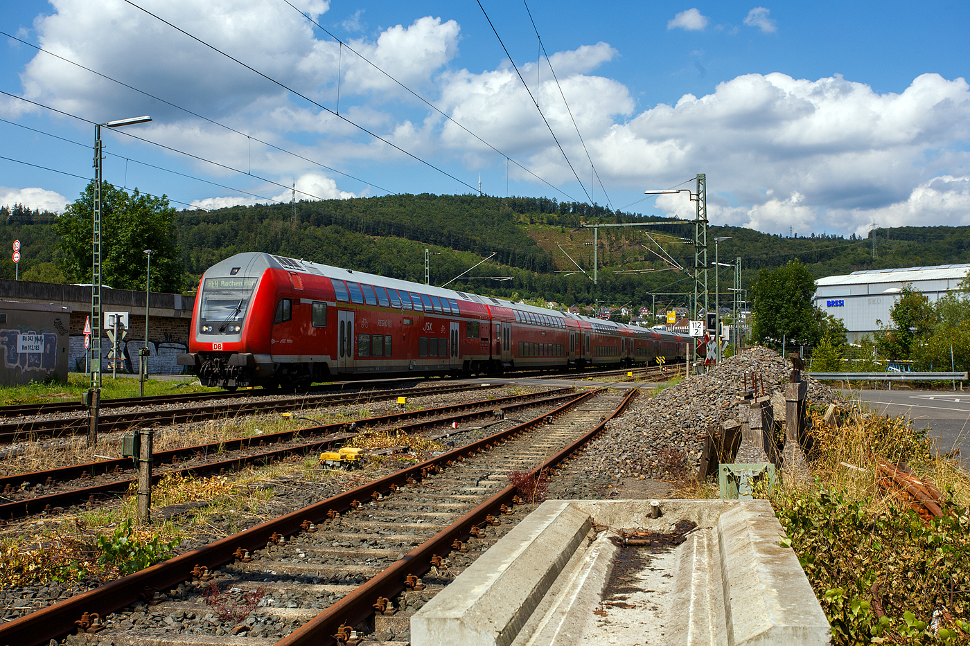 Steuerwagen voraus fährt am 22 Juli 2024 der RE 9 (rsx - Rhein-Sieg-Express) Siegen – Köln –Aachen, der DB Regio NRW durch Niederschelden bzw. Niederschelderhütte in Richtung Betzdorf (Sieg), hier beim Bü 343 – km 112,183 der Siegstrecke KBS 460. Der Zug überquert hier, wie so oft, die Sieg und somit die Landesgrenze von Nordrhein-Westfalen und Rheinland-Pfalz. Die Lok und der hintere Zugteil befinden sich in Siegen-Niederschelden (Nordrhein-Westfalen), der Steuerwagen und der 2. Wagen befinden sich nun in Mudersbach-Niederschelderhütte (Rheinland-Pfalz). 

Schublok war die 146 003-9.