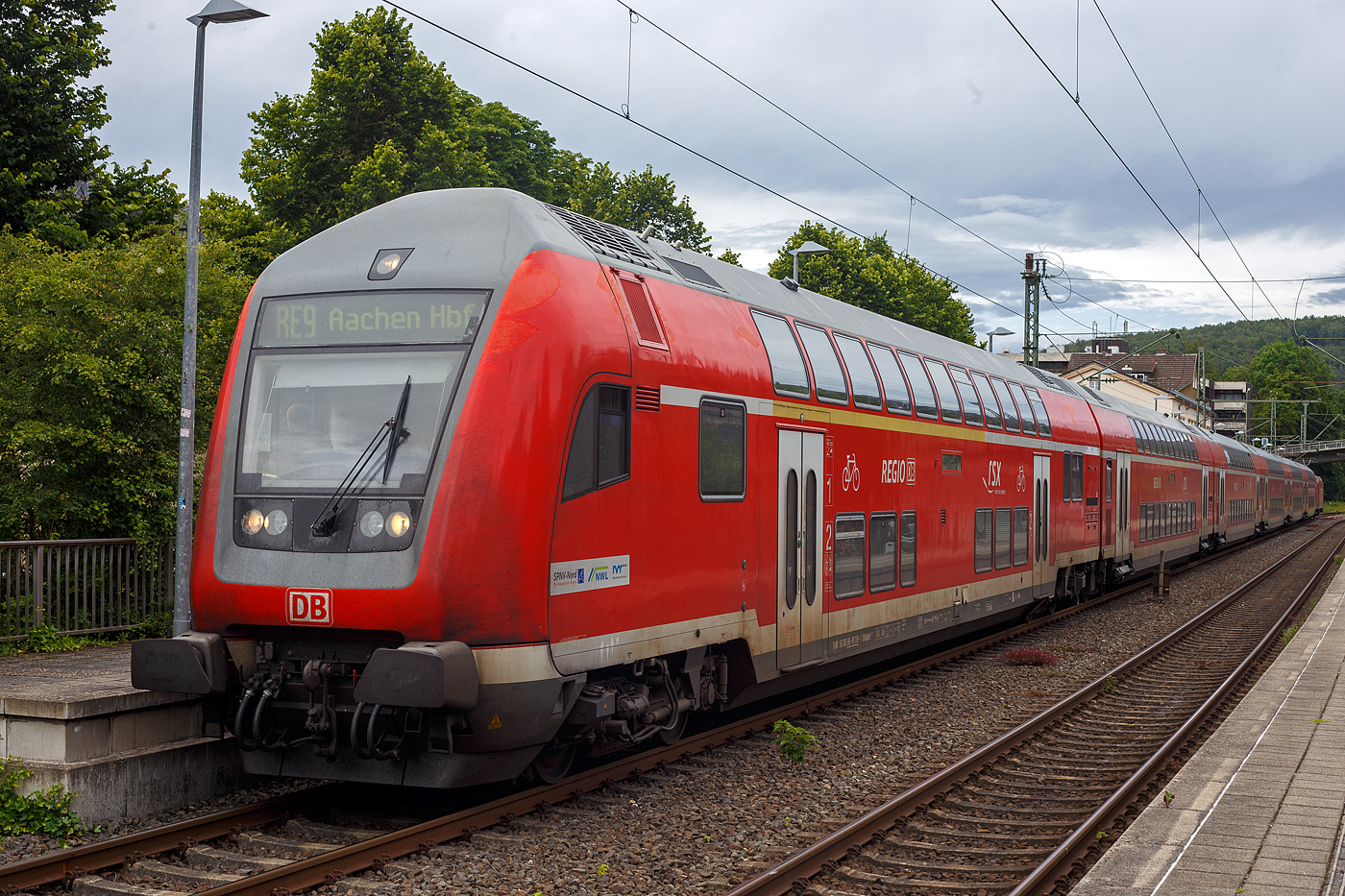 Steuerwagen voraus hat der RE 9 rsx - Rhein-Sieg-Express (Siegen – Köln – Aachen) am 21 Juni 2024 den Bahnhof Kirchen/Sieg erreicht. Auffällig ist das die Doppelstockgarnituren zurzeit mit sechs Dosto-Wagen gefahren werden, anstelle der ansonsten mit fünf Wagen. Ob dies der Fußball EM geschuldet ist, weiß ich aber nicht.

Vorne der klimatisierte 1./2. Klasse Doppelstock-Steuerwagen (DoSto-Steuerwagen) ist der D-DB 50 80 86-81 118-1 der Gattung DABpbzfa 767.3. Von der Bauart 767.3 gibt es auch nur 2 Stück diesen und den 119-9 beide sind beim Rhein-Sieg-Express (RE 9) im Einsatz. Schublok war die 146 005-4 der DB Regio NRW.

TECHNISCHE DATEN vom Steuerwagen:
Hersteller: Bombardier Werk Görlitz, ex Deutsche Waggonbau AG (DWA)
Baujahr: 2010
Spurweite: 1.435 mm
Länge über Puffer: 27.270 mm
Wagenkastenlänge: 26.660 mm
Wagenkastenbreite: 2.784 mm
Höhe über Schienenoberkante: 4.631 mm
Drehzapfenabstand: 20.000 mm
Achsstand im Drehgestell: 2.500 mm
Drehgestellbauart: Görlitz VIII
Leergewicht: 53 t
Höchstgeschwindigkeit: 160 km/h
Bremsbauart: KE-PR-A-Mg-mZ (D)
Sitzplätze: 38 (1.Klasse) / 41 (2. Klasse)
Toiletten: 1, behindertengerecht, geschlossenes System
Bemerkungen: 2 Mehrzweckabteil, 1 Dienstraum, uneingeschränkt dieselloktauglich
