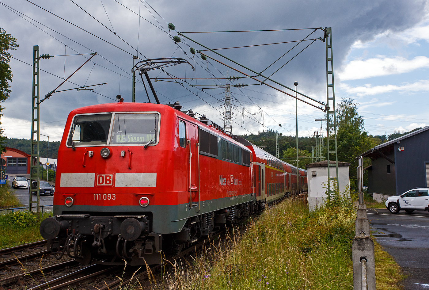 Steuerwagen voraus rauscht der RE 9 rsx - Rhein-Sieg-Express (Siegen – Köln – Aachen) am 12 Juni 2024 durch den Bahnhof Scheuerfeld (Sieg) in Richtung Köln. Hier im Nachschuss auf die schiebende 111 093-1 (91 80 6111 093-1 D-DB) der DB Regio NRW bzw. der DB-Gebrauchtzug. Die Zugzielanzeige ist hier falsch, es müsste eigentlich Aachen Hbf angezeigt sein, hier steht sie noch auf der Gegenrichtung.

Die Lok wurde 1978 von Krupp unter der Fabriknummer 5430 gebaut, der elektrische Teil wurde von AEG unter der Fabriknummer 8972 geliefert.