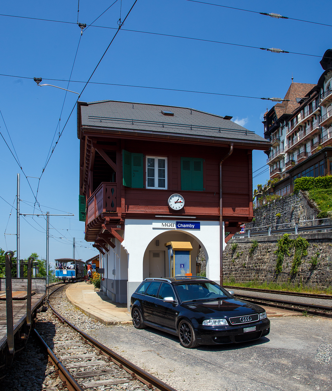 Über dem Genfersee, der Bahnhof Chamby am 27.05.2023.

Der Bahnhof Chamby ist ein Keilbahnhof, und liegt an der MOB (Montreux–Berner Oberland-Bahn) Strecke (KBS 120) Montreux–Montbovon–Zweisimmen, von hier zweigt die Strecke (KBS 115) nach Blonay ab, diese wird in der Sommersaison von der Museumsbahn, gehört aber der Transports Montreux–Vevey–Riviera (MVR, ex CEV). Hinter dem Bahnhofsgebäude der MOB befindet sich hier auch ein Ticketschalter der Museumsbahn BC. Links steht die G 2/2 Nr. 4 (020T) Krauss-Kastendampflok (Tramlok), der Museumsbahn Blonay–Chamby, mit dem vorgestellten zweiachsigen haboffenen Personenwagen (Sommerwagen) ex LCD C 21.
