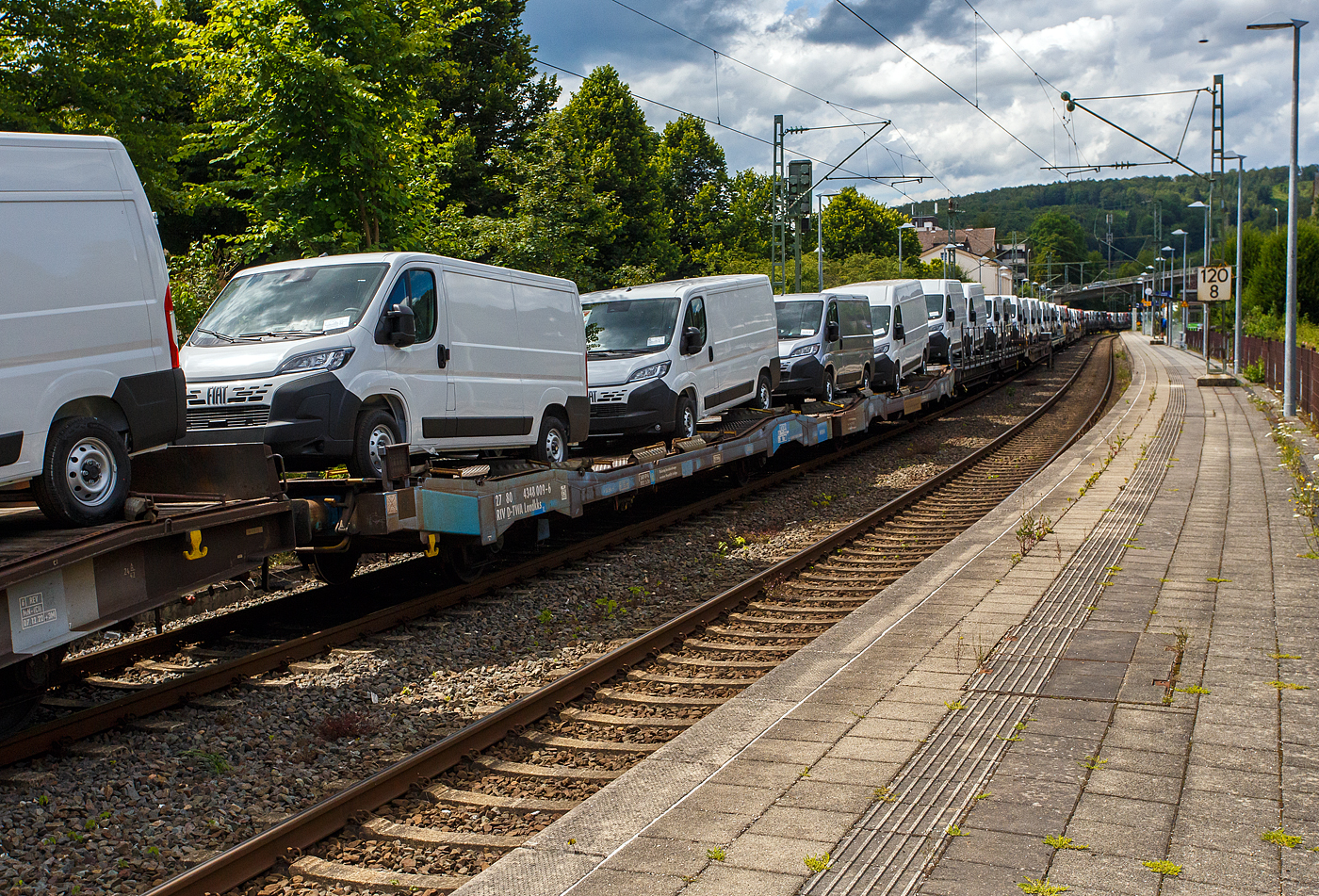 Vierachsige (2 x 2 achsige) lange Flachwageneinheit mit abgesenktem Fu�boden und Radvorlegern der TRANSWAGGON GmbH, der Gattung Laadkks (TWA 850 RV), 27 80 4348 009-6 D-TWA, beladen mit 4 Nutzfahrzeuge (FIAT - Kastenwagen), 14 Juli 2024 im Zugverband bei einer Zugdurchfahrt im Bahnhof Kirchen (Sieg).

TECHNISCHE DATEN:
Gattung: Laadkks (TWA 850 RV)
Spurweite: 1.435 mm
Anzahl der Achsen: 4 (2 x 2)
L�nge �ber Puffer : 30.980 mm
Ladel�nge : 29.740 mm 
Ladebreite : 3.100 mm 
Fu�bodenh�he �ber SOK: 850 / 1.000 mm
H�chstgeschwindigkeit: 100 km/h  / 120 km/h (leer)
Eigengewicht: 29.200 kg
Nutzlast: 42,8 t ab Streckenklasse B
Achsabst�nde: 9.000 mm / 6.480 mm / 9.000 mm 
Kleinster befahrb. Gleisbogenhalbmesser: 75 m
Bremse: 2x KE-GP-A (LL)
Intern. Verwendungsf�higkeit: RIV
