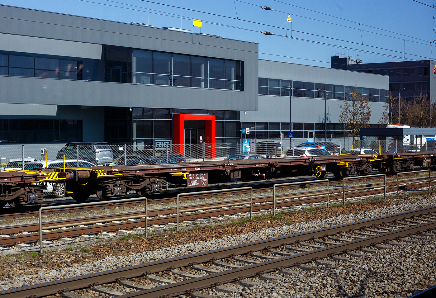 Vierachsige Drehgestell-Containertragwagen 60´ mit stoßgedämpfter Ladebühne, 31 81 4544 300-4 A-RCW, der Gattung Sgjns, der Rail Cargo Group (zu ÖBB) steht am 04 April 2025 im Zugverband in Wels (A). Aufnahme aus einem Zug. 

Bei dem Wagen handelt es sich um einen Güterwagen der Type Sgjns, ein
4-achsiger Drehgestell-Flachwagen in Sonderbauart. Er ist für den Transport
von Containern mit einer Gesamtlänge bis zu 60 Fuß geeignet. Als Besonderheit besitzen die Wagen eine stoßgedämpfte Ladebühne.

TECHNISCHE DATEN:
Spurweite: 1.435 mm (Normalspur)
Anzahl der Achsen: 4 in zwei Drehgestellen
Länge über Puffer: 21.000 mm
Drehzapfenabstand: 15.800 mm
Achsabstand im Drehgestell: 1.800 mm
Laufraddurchmesser: 920 mm (neu)
Ladelänge: 18.400 mm
Ladefläche: 44,5 m²
Höhe der Ladeebene über SOK: 1.180 mm
Eigengewicht: 23.000 kg
Max. Zuladung: 57,0 t (ab Streckenklasse C) / 62,0 t bei Streckenklasse D
Max. Geschwindigkeit: 100 km/h (beladen) / 120 km/h (leer)
Kleinster bef. Gleisbogenradius: R 75 m
Bremse: O-GP-A (LL)
Bremssohle: IB 116
Feststellbremse: Ja
Verwendungsfähigkeit: RIV
