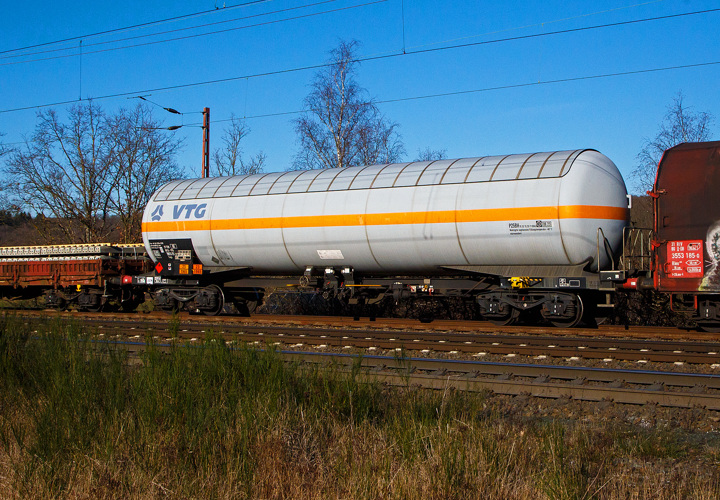 Vierachsiger 113 m³ Drehgestell-Druckgaskesselwagen, 37 80 7813 216-8 D-VTG, der Gattung Zags (mit Sonnendach), der VTG (Hamburg) am 07.02.2023 im Zugverband bei einer Zugdurchfahrt in Wilnsdorf-Rudersdorf.

Der Wagen wurde 1981 von LHB Salzgitter (Linke-Hofmann-Busch) gebaut.

Die Gefahrguttafel zeigt an (was drin ist):
Oben die Gefahrenzahl 23: Gas entzündbar
Unten die UN-Nummer 1965: Kohlenwasserstoffgas, Propan-Butan Gemische, verflüssigt. Hier Gemisch C (Propan).

TECHNISCHE DATEN (gem. Anschriften) :
Spurweite: 1.435 mm
Achsanzahl: 4 (in 2 Drehgestelle)
Länge über Puffer : 18.000 mm
Drehzapfenabstand: 12.100 mm
Achsabstand im Drehgestell: 1.800 mm
Höchstgeschwindigkeit: 100 km/h (beladen) / 120 km/h (leer)
Eigengewicht: 32.425 kg
Gesamtvolumen: 113 m³
Tankcode:  P25BH
Intern. Verwendungsfähigkeit: TEN-GE