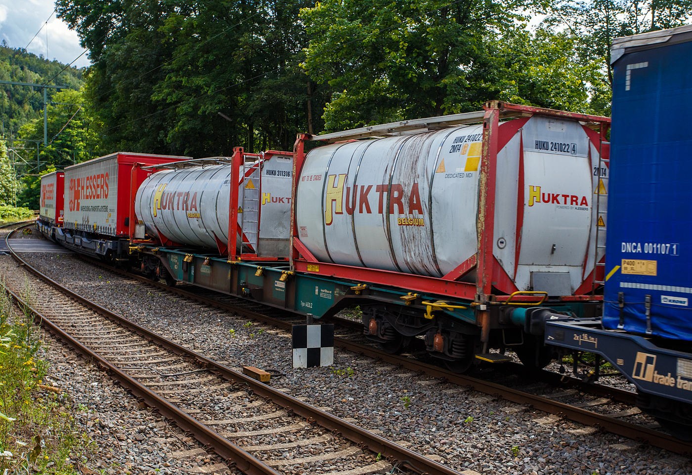 Vierachsiger Drehgestell-Containertragwagen 33 88 4554 285-5 B-LNS der Gattung Sgns (LINEAS Wagon Type 6453L2), der LINEAS Group NV/SA am 14 Juli 2024 im Zugverband bei der Zugdurchfahrt in Kirchen an der Sieg. Hier beladen mit zwei 20 Fuß Tankcontainern.

Die Lineas Group nv/sa (ex B-Logistics, ex B Cargo) ist eine belgische Schienengütergesellschaft.

TECHNISCHE DATEN:
Spurweite: 1.435 mm
Länge über Puffer: 19.740 mm
Drehzapfenabstand: 14.200 mm
Achsabstand in den Drehgestellen: 1.800 mm
Ladelänge: 18.400 mm
Ladefläche: 35 m²
Höhe der Ladeebene über S.O.: 1.155 mm
Eigengewicht: 19.400 kg
Max. Zuladung: 69,8 t (ab Streckenklasse D)
Max. Geschwindigkeit: 100 km/h
Kleinster befahrbarer Gleisbogen: R 75 m
Bremse: KE-GP-A (LL)
Bremssohle: IB 116
Feststellbremse: Nein
Verwendungsfähigkeit: RIV

