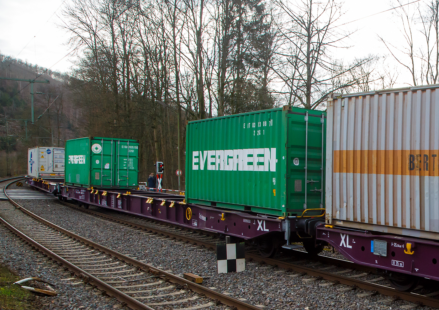 Vierachsiger Drehgestell-Containertragwagen 37 84 4576 291-7 NL-RRL, der Gattung Sggnss-xl (Sggnss 80’XL), der niederländischen Vermietungsfirma RailRelease B.V. (Rotterdam), am 04.02.2023 im Zugverband bei der Zugdurchfahrt im Bahnhof Kirchen (Sieg). Hier beladen mit zwei 20ft-Container.

Der Wagen wurde Tatravagonka Poprad (Slowakei) gebaut, das Baujahr konnte ich nicht erkennen. Mit dem Containertragwagen der Bauart Sggnss 80´ ist es erstmals möglich Container mit einer Gesamtlänge von 80 Fuß auf einem vierachsigen Drehgestellwagen zu transportieren. Der Wagen hat eine Länge von 25.940 mm. 

Der LIGHT EIGHTY Sggnss-xl wurde von TATRAVAGÓNKA schon 2010 auf Veranlassung von METRANS entwickelt. Nicht nur dank seinem geringen Gewicht von 22,4 t, sondern auch wegen den einzigartigen Lademöglichkeiten (5 Container­Bauarten und Wechselaufbauten in 30 verschiedenen Containerkombinationen) hat sich dieser Wagen schnell auf dem Markt etabliert. Im Vergleich zum 80’ langen Standardwagen kann bei dieser Variante ein Wagen mehr in Güterzüge aufgenommen werden. Durch die neuartige Konstruktion dieses TSI­‐konformen Wagens konnte nicht nur der Lärmpegel auf einen Messwert von 78 dB(A) reduziert werden. Eine Energieeinsparung von 20 % im Vergleich zum 80’-langen Standardgelenkwagen ermöglicht eine weitere Steigerung der Transporteffizienz. Weniger Drehgestellbedarf bedeutet weniger Instandhaltungsaufwand für Bremssysteme.

TECHNISCHE DATEN:
Spurweite: 1 435 mm
Anzahl der Achsen: 4 in zwei Drehgestellen
Länge über Puffer: 25.940 mm
Drehzapfenabstand: 19.300 mm
Achsabstand im Drehgestell: 1.800mm
Laufraddurchmesser: 920 mm (neu)
Drehgestell- und Laufradtyp: Y25Ls1-K  / Ba303
Ladelänge : 24 700 mm  (z.B. 2 x 40’ ISO Container)
Höhe der Ladeebene über SOK: 1.155 mm
Höchstgeschwindigkeit: 100 km/h, bei Lastgrenze SS und leer 120 km/h
Max. Zuladung bei Lastgrenze S: 67,6 t (ab Streckenklasse D)
Max. Zuladung bei Lastgrenze SS: 57,6 t (ab Streckenklasse C)
Eigengewicht: 22.400 kg
Kleinster bef. Gleisbogenradius: R 75 m (150 m im Zugverband)
Bauart der Bremse: KE-GP-A (K)
Bremssohle: C 333 (CoFren, gesintert)
Handbremse: Ja
Intern. Verwendungsfähigkeit: TEN-GE

