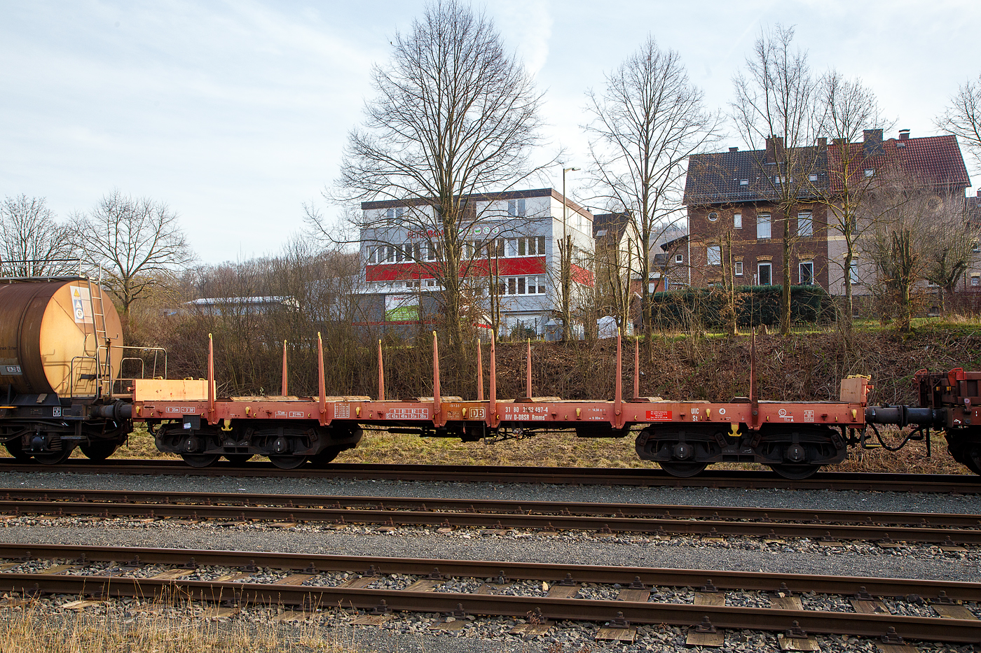 Vierachsiger Drehgestell-Flachwagen mit Drehrungen und Stirnwandklappen, 31 80 3962 497-4 D-DBSR, Gattung Rmms 664, der DB Cargo Romania SRL (ex DB Schenker Rail Romania), am 09.02.2023 leer abgestellt auf dem KSW Rbf Herdorf (Betriebsst�tte Freien Grunder Eisenbahn - NE 447).

Der Wagen wurde 1976 von der Waggon Union in Berlin gebaut.

Der Wagen ist f�r den Transport von Walzwerkerzeugnissen Stra�enfahrzeugen einschl. Kettenfahrzeugen, Erzeugnissen der Bauindustrie, usw. geeignet. Die an den Stirnseiten angeordneten �berfahrklappen gestatten abgeklappt das Durchfahren von Gleisb�gen mit mindestens 150 m Halbmesser. Die �berfahrklappen liegen im abgeklappten Zustand auf 4 Konsolen auf. In senkrechter Stellung werden sie durch je 2 am Kopfst�ck angeordneten Fallrungen gehalten. Je Wagenl�ngsseite sind 6 absenkbare Drehrungen vorhanden. Der Fu�boden besteht aus Kiefernbohlen mit den Abmessungen 70 x 180 mm. Er kann eine Radlast von 5,0 t aufnehmen. Im Fu�boden sind 6 geteilte, klappbare Ladeschwellen eingebaut. Die Wagen haben eine Klotzbremse mit stufenlos, selbstt�tiger Lastabbremsung.

TECHNISCHE DATEN:
Spurweite: 1.435 mm (Normalspur)
Gattung/Bauart: Rmms 664
Erstes Baujahr: 1968
Anzahl der Achsen: 4 in 2 Drehgestellen
L�nge �ber Puffer: 14.040 mm
Drehzapfenabstand: 9.000 mm
Achsabstand im Drehgestell: 1.800 mm
Ladel�nge: 12.600 mm
H�chstgeschwindigkeit: 100 km/h (beladen) / 120 km/h (leer)
Eigengewicht: 21.400 kg
Maximale Ladegewicht: 59,0 t (ab Streckenklasse C)
Laufraddurchmesser (neu): 920 mm
Kleinster bef. Gleisbogenradius: 35 m
Bauart der Bremse: KE-GP-A max. 56 t (LL)
Bremssohle: IB 116 
Internationale Verwendungsf�higkeit: RIV