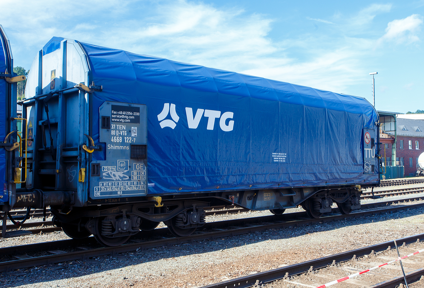 Vierachsiger Drehgestell-Flachwagen mit verschiebbarem Planenverdeck und Lademulden f�r Coiltransporte, 37 80 4668 122-7 D-VTG, der Gattung Shimmns (-ttu), der VTG Rail Europe GmbH (Hamburg), abgestellt am 17.09.2023 beim KSW Bahnhof Siegen-Eintracht. Hier war im Rahmen der  Europ�ische Mobilit�tswoche  der „Tag der Schiene 2023“ ein Tag der offenen T�r. 

Diese Wagen sind speziell f�r den Transport witterungsempfindlicher Blechrollen (Coils) bestimmt. Er besitzt feste Stirnw�nde, 5 fest im Untergestell eingebaute Lademulden. Die Wagenabdeckung erfolgt mit einer PVC-beschichteten Gewebeplane, die auf 11 Rohrrahmen aufliegt. �ber Laufwagen ist das Planendach in Wagenl�ngsrichtung verschiebbar. Die Verriegelung des Planendaches an den Stirnw�nden erfolgt �ber eine 4-Punkt-Zentralverriegelung, die sowohl vom Erdboden als auch von der Rampe aus bedient werden kann. Das Planenverdeck l�sst sich an einem Wagenende so weit zusammenschieben, dass ca. 2/3 der Ladefl�che zur Beladung freigegeben wird. Hierdurch ist eine einfache Beladung des Wagens sowohl von oben als auch von der Seite aus m�glich. 

TECHNISCHE DATEN:
Spurweite: 1.435 mm
Achsanzahl: 4 (in 2 Drehgestelle)
L�nge �ber Puffer: 12.040 mm
L�nge der Ladefl�che: 10.800 mm
Drehzapfenabstand: 7.000 mm
Achsabstand im Drehgestell: 1.800 mm
Eigengewicht: 22.250 kg
H�chstgeschwindigkeit: 100 km/h (beladen) / 120 km/h (leer)
Maximales Ladegewicht: 67,7 t (ab Streckenklasse D4)
Kleinster bef. Gleisbogenradius: 35 m
Bauart der Bremse: KE-GP-A (K)
Bremssohle: C 810
Intern. Verwendungsf�higkeit: TEN-GE
