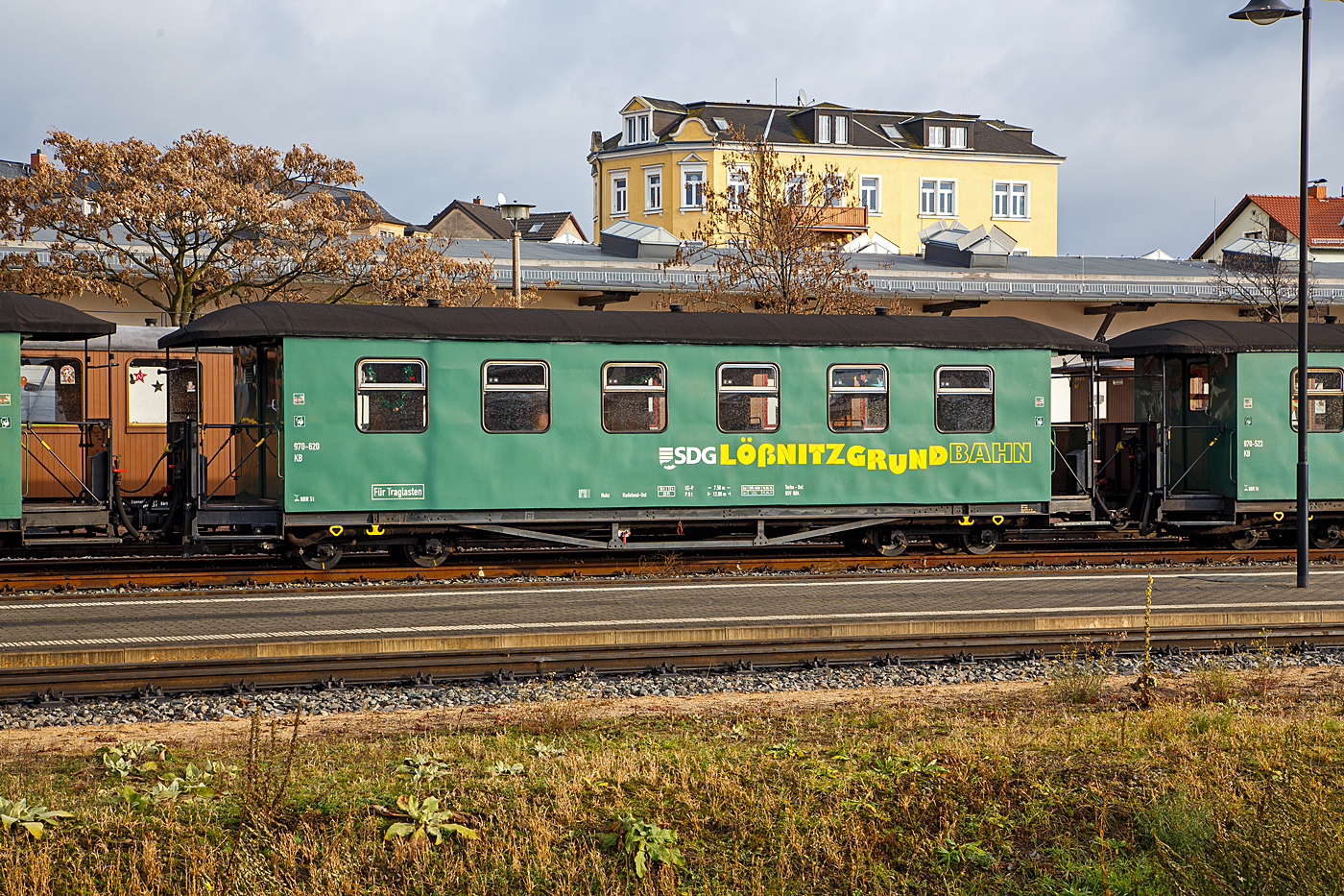 Vierachsiger modernisierter 750 mm-Schmalspur 2.Klasse Personenwagen mit Traglastenabteil, offenen Plattformen und Holzdach, SDG 970-620 (ex DB 970-620, ex DR 970-620), der Gattung KB4 tr, der SDG - Sächsische Dampfeisenbahngesellschaft mbH abgestellt im Zugverband am 07.12.2022 beim Schmalspur-Bahnhof Radebeul Ost (Lößnitzgrundbahn).

Der Wagen wurde 1928 von den Linke-Hofmann-Busch-Werke in Bautzen für die Deutsche Reichsbahn Gesellschaft (DRG) gebaut. Er ist einseitig als Traglastenwagen (für Kinderwagen etc.). Diese in den zwanziger Jahren gefertigten Wagen, haben gegenüber den Erstserien nun blechbeplankte Außenwände. Auch hielten Dampfheizung und Saugluftbremse Einzug. Die bei der Deutschen Reichsbahn verbliebenen Wagen wurden teilweise umgebaut und technisch angepasst. Ende der siebziger Jahre wurde ein Teil der Wagen modernisiert. Diese erhielten dabei ein völlig geändertes äußeres Erscheinungsbild. Mehrere dieser Traglastenwagen sind heute noch bei verschiedenen sächsischen Schmalspurbahnen und Museumsbahnen im Einsatz.

Die älteren Nummern der Deutsche Reichsbahn (1950 - 1958) 7.xxxx, der Deutsche Reichsbahn Gesellschaft / DR (1927 - 1950) K 3xx, sind mir leider unbekannt.

TECHNISCHE DATEN:
Spurweite: 750 mm
Anzahl der Achsen: 4
Länge über Puffer: 12.800 mm
Drehzapfenabstand: 7.500 mm
Eigengewicht: 10 t
Sitzplätze: 29 (in der 2. Klasse)
Bremse: KE-