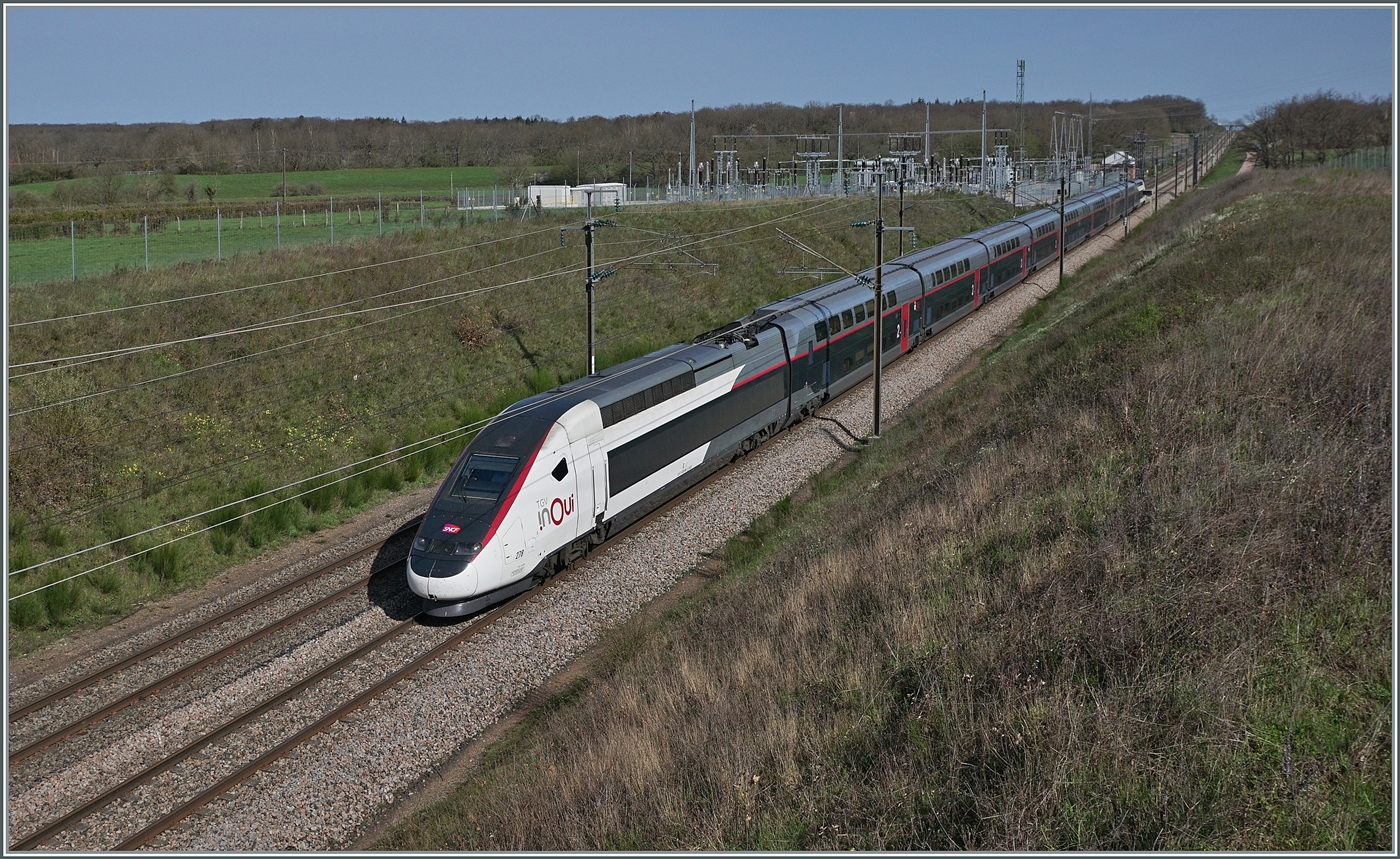 Voilà, der SNCF TGV Rame 278 ist als SNCF iNOUi TGV 6937 von Paris Gare de Lyon (ab 09:46) nach Annecy (an 13.28) auf der Schnellfahrstrecken Paris - Lyon bei Saint Émiland in voller Fahrt unterwegs unterwegs. 
Soweit der eigentliche Bildtext. Schon seit längerem reizt mich die Fotografie schneller Züge. Seit die FS Trenitalia ETR nach Paris fahren rückte die TGV Strecken Paris - Lyon ganz besonders in den Fokus. Doch man geht nicht eben hin, wartet und drück ab. Es brauchte eine länger Vorbereitung. Allein die Kalkulation, WANN der Zug vorbeifährt ist nicht ganz einfach, gelang mit aber auf gut 6 Minuten Genauigkeit. Die Fotostelle auch nicht einfach eine geeignete zu finden, diese hier war  Plan B , nachdem ich die ursprüngliche nicht auf Anhieb fand. Dann die lange Anfahrt! Da wir eine Autobahnausfahrt verpassten, schmolz die üppige kalkulierte Zeit wie Schnee im Sommer und wenige Minuten nach der Ankunft kam auch schon der ETR 400; es waren also echt spannende Fotomoment zum Ferienanfang, bei immerhin perfekt passendem Wetter.
Übrigens, das  Wissen , das dieses Bild den TGV Paris- Annecy zeigt, passiert auf der Tatsache dass dieser Zug 17 Minuten nach dem ETR 400 in Pairs abfährt, da die Strecke sehr stark befahren ist, bin ich noch dabei, die andern Züge auszurechnen, was durch die gegebenen Unbekannte Abfahrt und Bestimmungsstation doch nicht ganz so einfach ist. 
6. April 2024