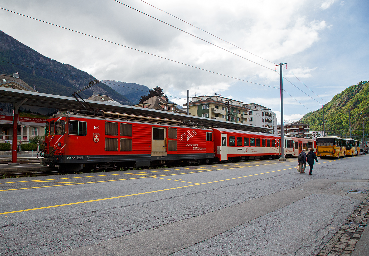 Von dem Gepäcktriebwagen Deh 4/4 II - 96  Münster   der 
Matterhorn-Gotthard-Bahn (MGB), ex FO 96  Münster   (Furka-Oberalp-Bahn), geschoben verlässt am 25.05.2023 der Regionalzug von Andermatt nach Visp den Bahnhof (Vorplatz) Brig.

Der Gepäcktriebwagen wurde 1984 von SLM (mechanischer Teil, Lokomotivkasten) und BBC (elektrische Ausrüstung) gebaut.