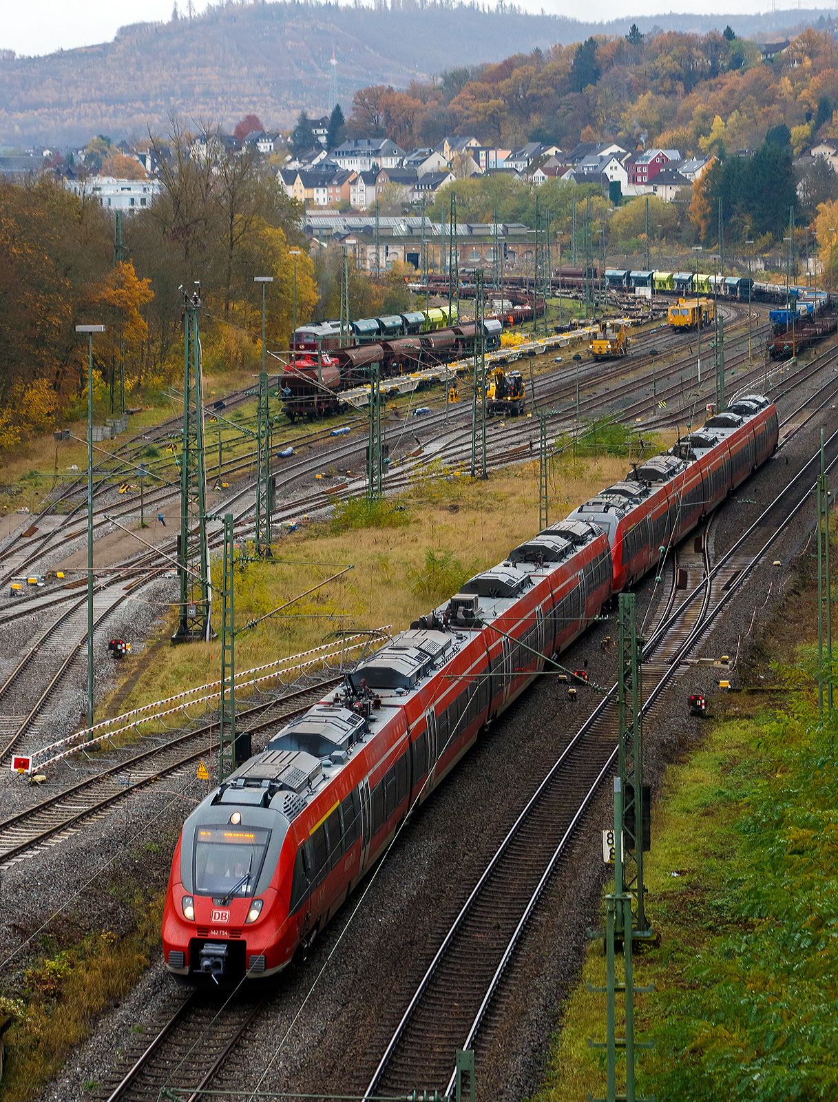 Zwei gekuppelte vierteilige Bombardier Talent 2 der DB Regio NRW haben 09 November 2025 den Bahnhof Betzdorf/Sieg verlassen und fahren als RE 9 – RSX / Rhein Sieg Express (Siegen - Köln – Aachen) weiter in Richtung Köln. 

Hinten im Rangierbahnhof (Rbf) werden die Gleise erneuert.