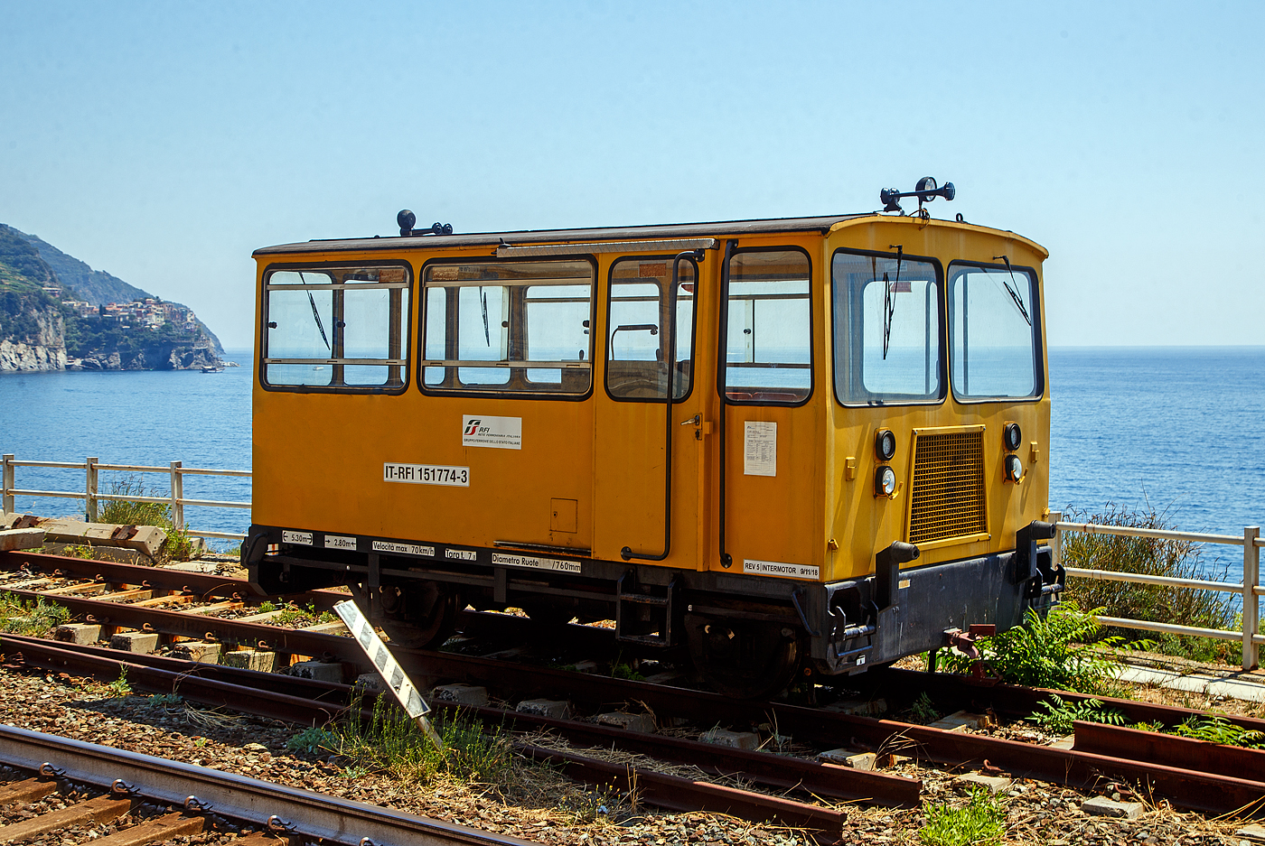 Zweiachsige Mannschafts-Draisine (Autocarrello della squadra) IT-RFI 151774-3 der RFI (Rete Ferroviaria Italiana) abgestellt am 21.07.2022 im Cinque Terre Bahnhof Corniglia. 

TECHNISCHE DATEN (laut Anschriften):
Spurweite: 1.435 mm
Achsanzahl: 2
L�nge �ber Puffer: 5.300 mm
Achsabstand: 2.800 mm
Treibraddurchmesser: 760 mm
H�chstgeschwindigkeit: 30 km/h / geschleppt 70 km/h
Eigengewicht: 7.800 kg

Hinten links auf den Felsvorsprung kann man Manarola erkennen.