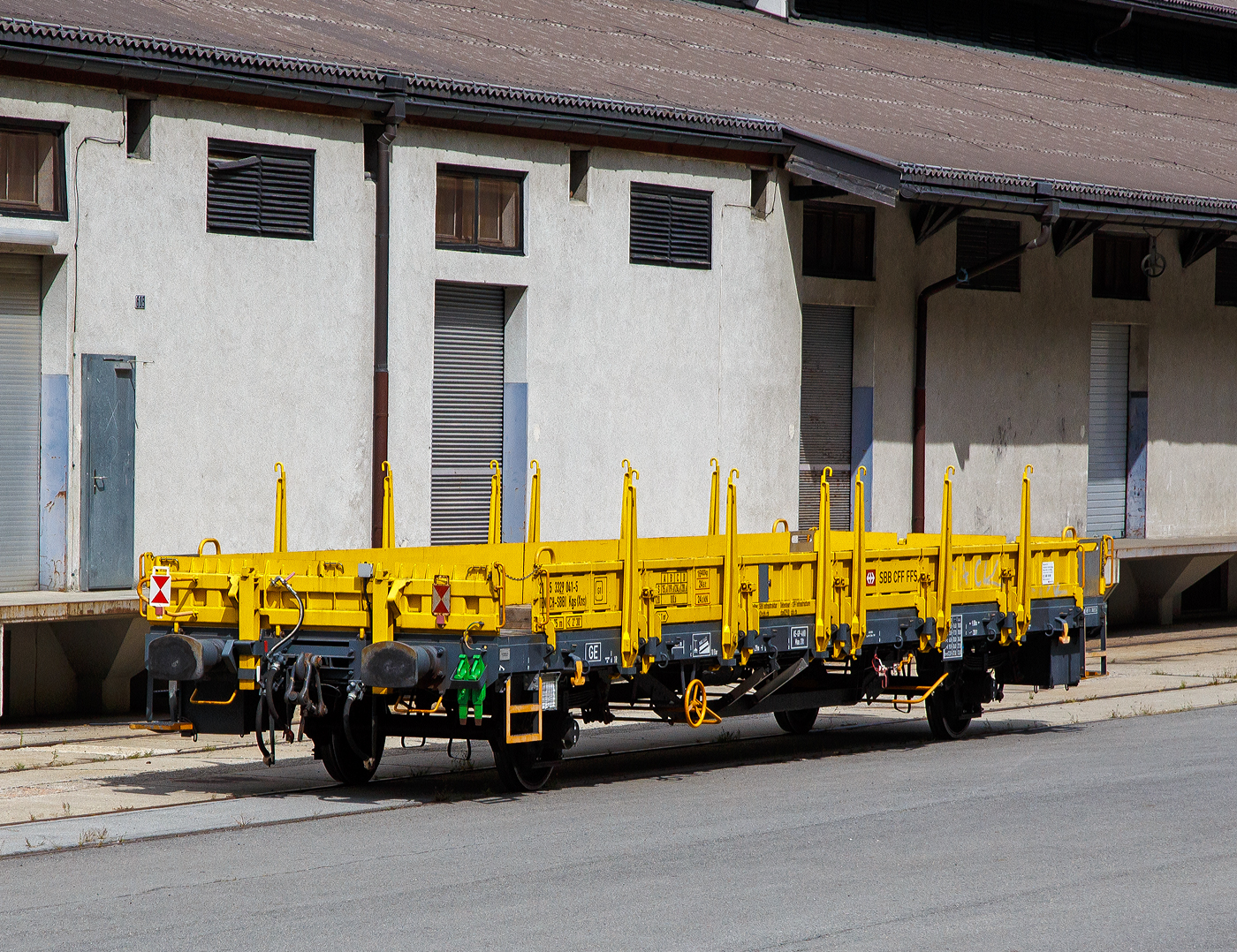 Zweiachsiger Flachwagen mit Seiten- und Stirnwandklappen, Seiten- und Stirnwandrungen, sowie Befestigungseinrichtungen f�r Container, 21 85 3329 041-5 CH-SBBI der Gattung Kgs (Xns) ein Kgs-G�terwagen/Xns- Dienstwagen Kgs der SBB Infrastruktur (vermutl. f�r Fahrleitungsdienst) abgestellt am 07 September 2021 beim SBB Depot in Brig, aufgenommen aus einem MGB-Zug heraus.

Die Wagen sind f�r den Transport von Walzwerkerzeugnissen, Baufertigteilen, Sch�ttg�tern, sperrigen G�tern, Stra�enfahrzeugen und Containern, kurzum ein universeller G�terwagen, auch f�r den Baubereich. Der Kgs ist ein zweiachsiger G�terwagen mit niedrigen Bordw�nden, umlegbaren Rungen, Holzboden und eingelassenen Containerhaken f�r den Transport von 10 , 20 , 30  und 40  Containern. 

Bedeutung der Gattung Kgs:
K – Flachwagen in Regelbauart mit zwei unabh�ngigen Rads�tzen mit klappbaren W�nden und kurzen Rungen Ladel�nge mindestens 12 m h�chste Lastgrenze 25 t bis 30 t

g - f�r den Transport von Containern eingerichtet

s - lauff�hig bis 100 km/h

TECHNISCHE DATEN des Wagens:
Spurweite: 1.435 mm
Achsanzahl: 2
L�nge �ber Puffer: 14.290 mm
Achsabstand: 9.000 mm
Ladel�nge zwischen den Stirnw�nden: 12.910 mm
Ladefl�che: 36,1 m�
H�chstgeschwindigkeit: 100 km/h (beladen) / 120 km/h (leer)
Eigengewicht: ca. 16.400 kg
max. Zuladung: 28,6 t (ab Streckenklasse D)
Kleinster bef. Gleisbogenradius: 75 m
Bauart der Bremse: KE-GP-A (K)
Bremssohle: Jurid 816 M
Handbremse: Ja
Intern. Verwendungsf�higkeit: TEN-GE