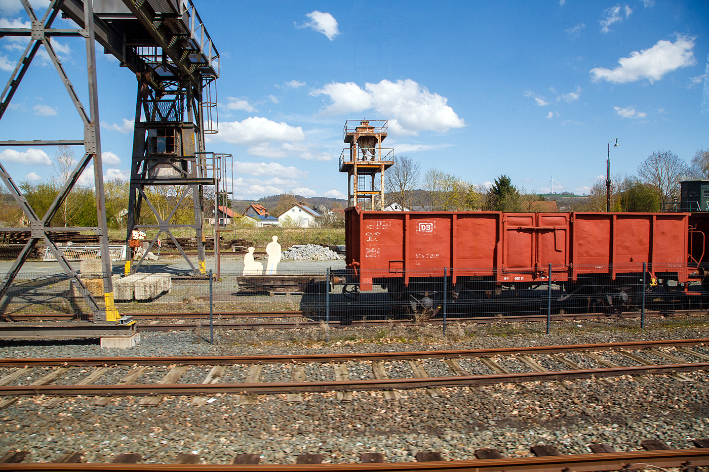 Zweiachsiger Hochbordwagen mit Bremserbühne, ex DB 80 514 7 039 der Gattung Eo 020 (ex Gattung Omm 55) am 21.04.2023 im Deutsche Dampflokomotiv-Museum (DDM) in Neuenmarkt (Oberfranken), aus einem fahrenden Zug heraus (durch die Scheibe) fotografiert.

Die Waggons der Bauart Omm 55 (später E 040 bzw. Eo 020) waren eine der großen Stütze im Wagenpark der Deutschen Bundesbahn. Insgesamt wurden bis 1962 über 17.300 Wagen beschafft. Rund 30% der Wagen wurden mit einer Bremserbühne geliefert. Da die Bauart dem UIC-Typ-2 entsprach, wurde er von zahlreichen weiteren europäischen Bahnverwaltungen gebaut und waren auch als RIV-EUROP-Wagen bekannt. Durch den rauen Alltagsbetrieb wurden Verstärkungen im Türbereich und der Ersatz der Seitenwände nötig. Am Ende ihrer Dienstzeit sah man sie häufig im saisonalen Rübenverkehr.

Die Bedeutung der Gattung:
E = Offener Güterwagen der Regelbauart mit zwei Radsätzen
o = nicht stirnkippbar

TECHNISCHE DATEN:
Spurweite: 1.435 mm
Länge über Puffer: 10.500 mm
Achsabstand: 5.400 mm
Ladelänge:  8760 mm
Ladehöhe: 1.500 mm
Ladefläche: 24,1 m²
Laderaum:  36,2 m³
Höchstgeschwindigkeit: 100 km/h
Maximales Ladegewicht: ca. 28,5 t
Eigengewicht: ca. 12 t
Kleinster bef. Gleisbogenradius: R 35 m
Bremse: KE-G
Handbremse: Ja
Intern. Verwendungsfähigkeit: RIV-EUROP