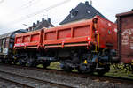 Vierachsiger zweimuldiger Drehgestell-Schüttgutkippwagen mit elektrohydraulischer Betätigung, 31 80 6770 466-4 D-DB, der Gattung Fans 128.2, der DB Cargo Deutschland AG, am 14 November 2025 im Zugverband bei einer Zugdurchfahrt in Kirchen/Sieg.

Der zweimuldige Drehgestell-Schüttgutkippwagen (Zweiseiten-Kastenkipper) ist für den Transport von feuchtigkeitsunempfindlichen Schüttgütern wie z.B. Splitt, Kies, Schotter, erdfeuchtem Sand, Bodenaushub oder Bauschutt vorgesehen. Der Wagen besitzt einen elektrohydraulischen Kippantrieb und eine speicherprogrammierbare Steuerung (SPS). Entwickelt und in Serie gebaut wurde der Kastenkipper vom FEW Fahrzeug- und Entwicklungswerk Blankenburg (Harz) der DB AG. Die Drehgestelle liefert das Werk Halle, die Wagenkästen fertigen das Werk Kaiserlautern und DWA Niesky.

Für den Einsatz als Einzelwagen, in Wagengruppen oder beim Massenschüttgut-Transport in Ganzzügen besitzt er eine autarke Wagentechnik, die eine von äußeren Energiequellen unabhängige Entladung ermöglicht. Das Schüttgut kann als Nah- oder Weitablage abgegeben werden. Das Schüttgut nach beiden Längsseiten gekippt werden. Der Wagen verfügt über zwei getrennt kippbare Mulden. Die Wagen haben eine Batterie die über Achsgeneratoren (hier im Bild am rechten Drehgestell) aufgeladen werden.

TENISCHE DATEN:
Erstes Lieferjahr: 1996
Spurweite: 1.435 mm (Normalspur)
Länge über Puffer: 11.600 mm
Drehzapfenabstand: 6.580 mm
Achsabstand im Drehgestell: 1.800 mm
Drehgestell-Bauart: Y 25 Lsd 1 - 629
Laufraddurchmesser: 920 mm (neu)
Laderaum: 2 x 18,0 m³
Ladefläche: 2 × 12,0 m²
Höhe der Beladeöffnung: 3.512 mm
Kippwinkel des Kastens: 45°
Kippantrieb Energieversorgung: autark, über Batterie geladen über Achsgenerator
Kippantrieb Kapazitätsverbrauch pro Entladung: 5 bis 10 (Ah)
Kippbewegungen: über zwei Hydraulikzylinder je Kasten
Höchstgeschwindigkeit: 120 km/h (leer) / 100 km/h (beladen)
Eigengewicht: 29.500 kg
Maximales Ladegewicht: 60,5 t (ab Streckenklasse D4), oder DB CM4 54,5 t
Kleinster bef. Gleisbogenradius: 75 m
Bremse: KE-GP-A (LL)
Bremssohle: IP 116
Intern. Verwendungsfähigkeit: RIV

Der Wagen ist zum Transport von witterungsunempfindlichem Schüttgut (mit einer max. Kantenlänge von 40 cm). Der Aufbau besteht aus zwei einzeln kippbaren Kästen mit einem Fassungsvermögen von je 18 m³, die wahlweise nach rechts oder links gekippt werden können. Dabei besteht die Möglichkeit, die Abwurfweite in zwei Stufen zu variieren; „nah“ für die Tiefbunkerentleerung und „weit“ für das ebenerdige Abkippen. Für die Bedienung des Wagens befinden sich an den Stirnwänden zwei diagonal angeordnete Bedientableaus. Der gesamte Kippvorgang erfolgt nach Vorwahl der gewünschten Funktion vollautomatisch. Die entsprechenden Magnetventile werden dabei elektrisch angesteuert. Bei Ausfall des elektrohydraulischen Kippantriebes (z.B. entladene Batterie) können mittels Handpumpe und Betätigung der Handnotbetätigung an der entsprechenden Wegeventilgruppe die Hydraulikzylinder bewegt werden. Eine detaillierte Anweisung für das Vorgehen bei Ausfall ist in jedem Wagen im Batteriekasten deponiert.
