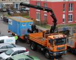 MAN TGM 18.330 Baukipper (Selbstlader) der Fa.NCC verlädt einen Bauaufenthaltscontainer auf Hänger, 09.12.13 Berlin-Pankow.