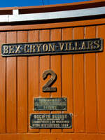 Die Beschilderung der elektrischen Zahnradlokomotive BGV He 2/2 2, später BVB He 2/2 2  La Grisette  der Museumsbahn Blonay–Chamby am 09 September 2023 im Museum Chaulin. Hier mit dem Schild der ehemaligen Chemin de fer électrique Bex = Gryon = Villars (BGV). Und den Fabrikschildern der CIEM - Compagnie de l’industrie électrique et mécanique (ab 1918 SAAS) und der SLM - Schweizerischen Lokomotiv- und Maschinenfabrik in Winterthur (hier in Französisch). 