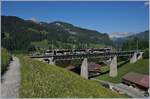 Der von Sarah Morris gestaltete MOB Lenkerpendel  Monarch  ABt 341 - Be 4/4 5001 - Bt 241 als Regionalzug 2531 Lenk - Rougemont auf dem 109 Meter langen Grubenbachviadukt kurz vor der Ankunft in Gstaad.

2. Juni 2020 